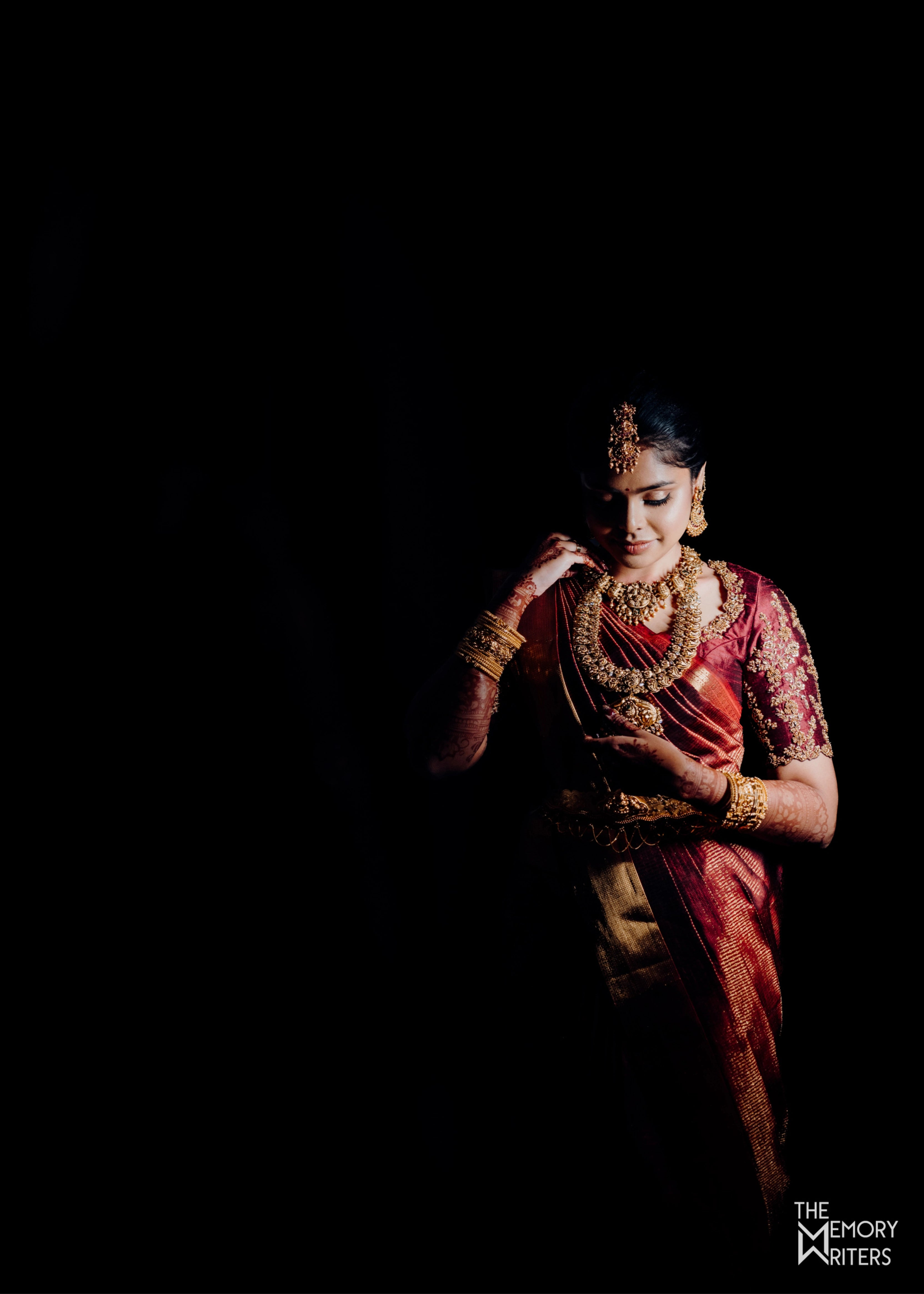 Bride Sangamithra from Coimbatore posing in a maroon rawsilk blouse, intricately handcrafted with sequins, zardozi, kundan and stones by team Archana Karthick.