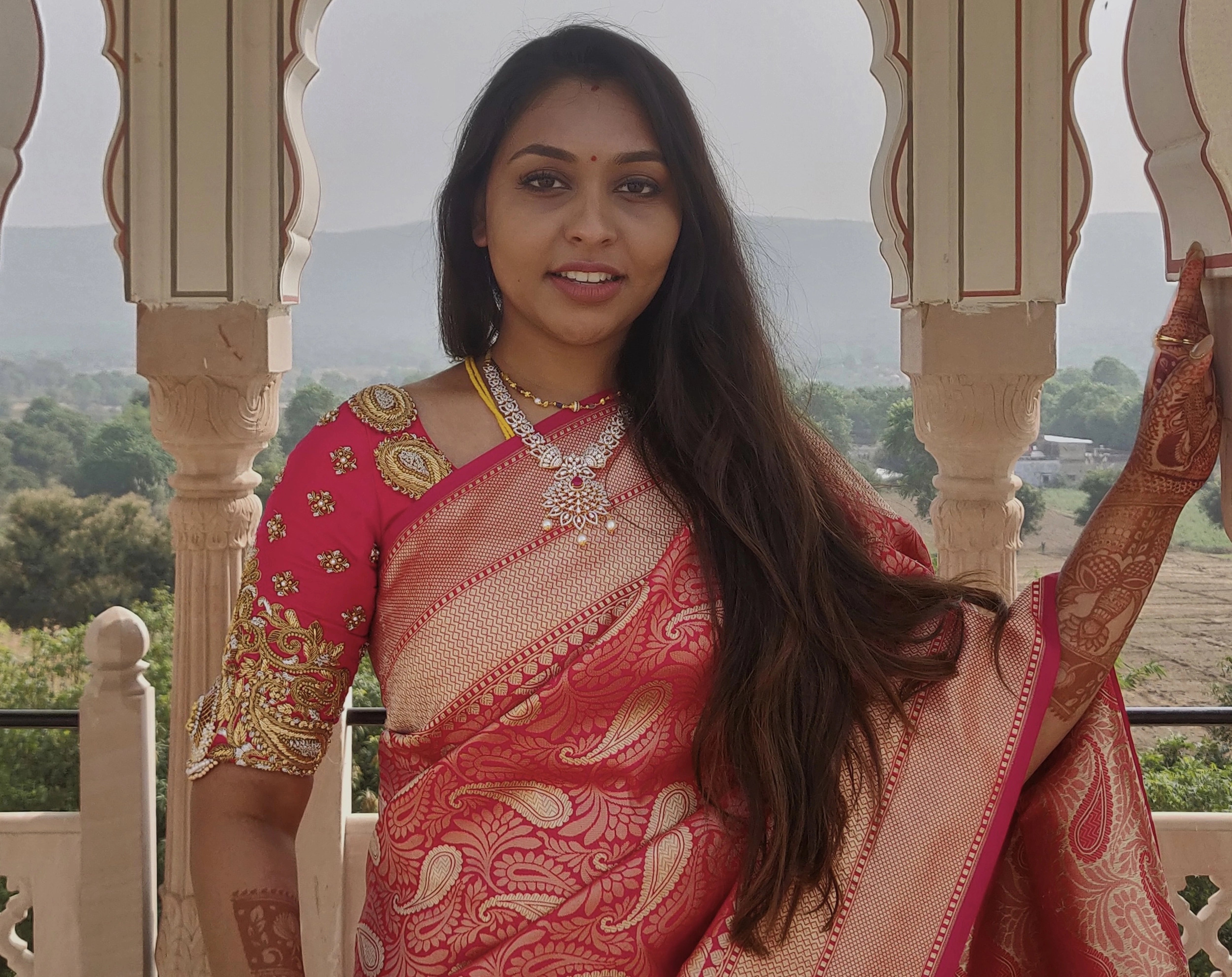Bride Sanjana in a pink silk blouse handcrafted by team Archana Karthick.