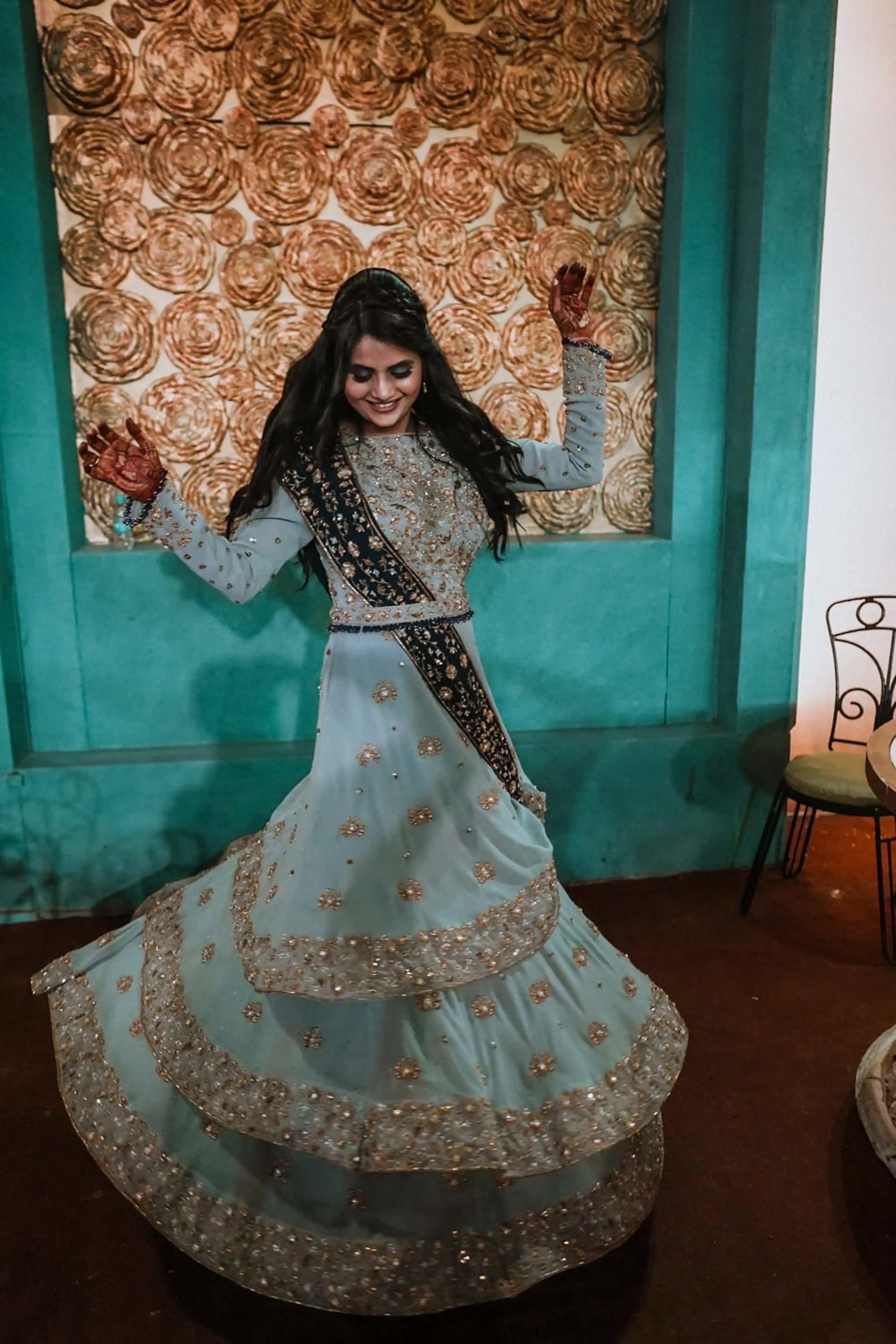 Bride Sapna Tapadia from Australia in a layered gown in aqua grey georgette, paired with a navy blue dupatta. Intricately handcrafted by team Archana Karthick.