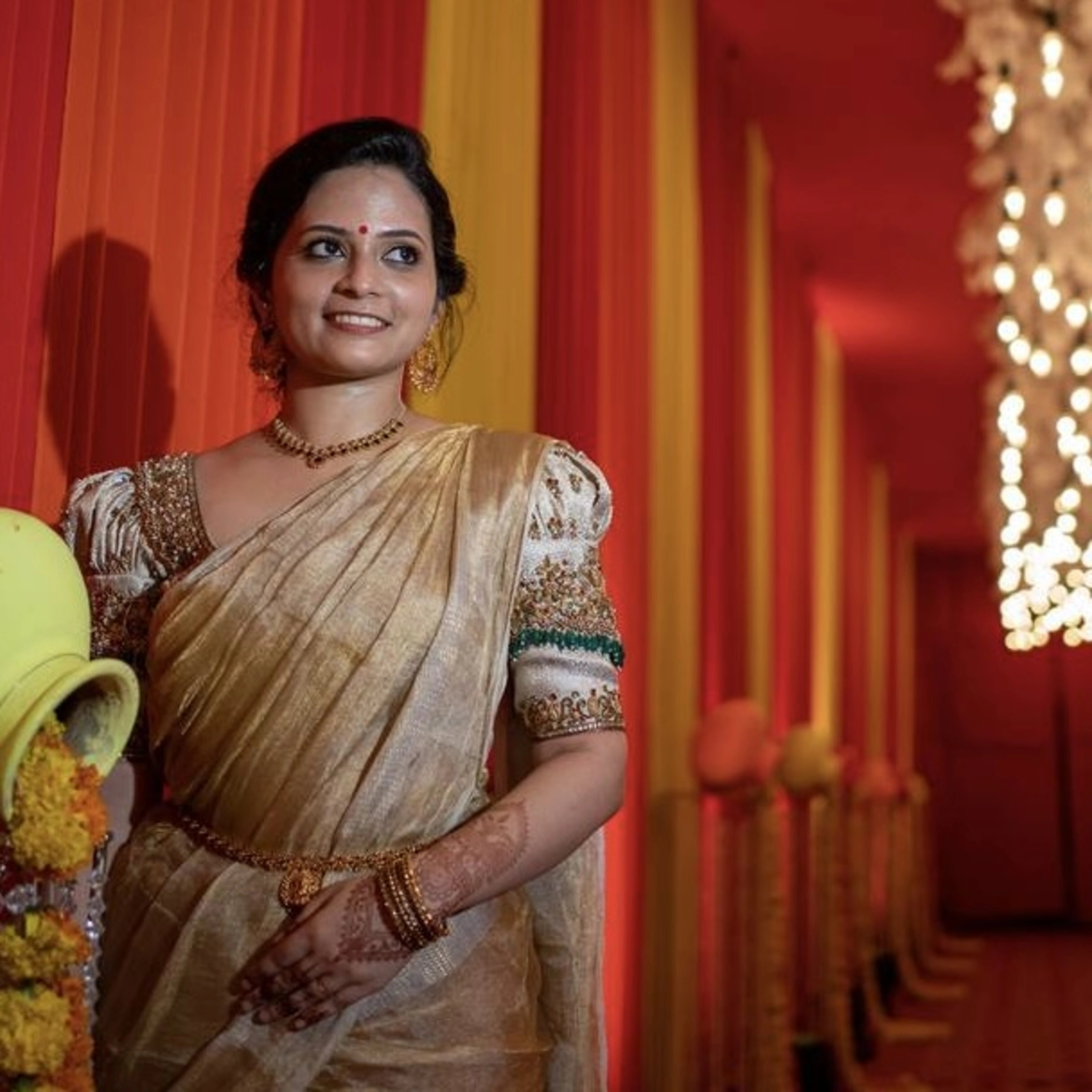 Bride Shalini S from Kerala in a handcrafted ivory silk blouse embellished with beads, zardozi, kemp stones & crystals by team Archana Karthick.