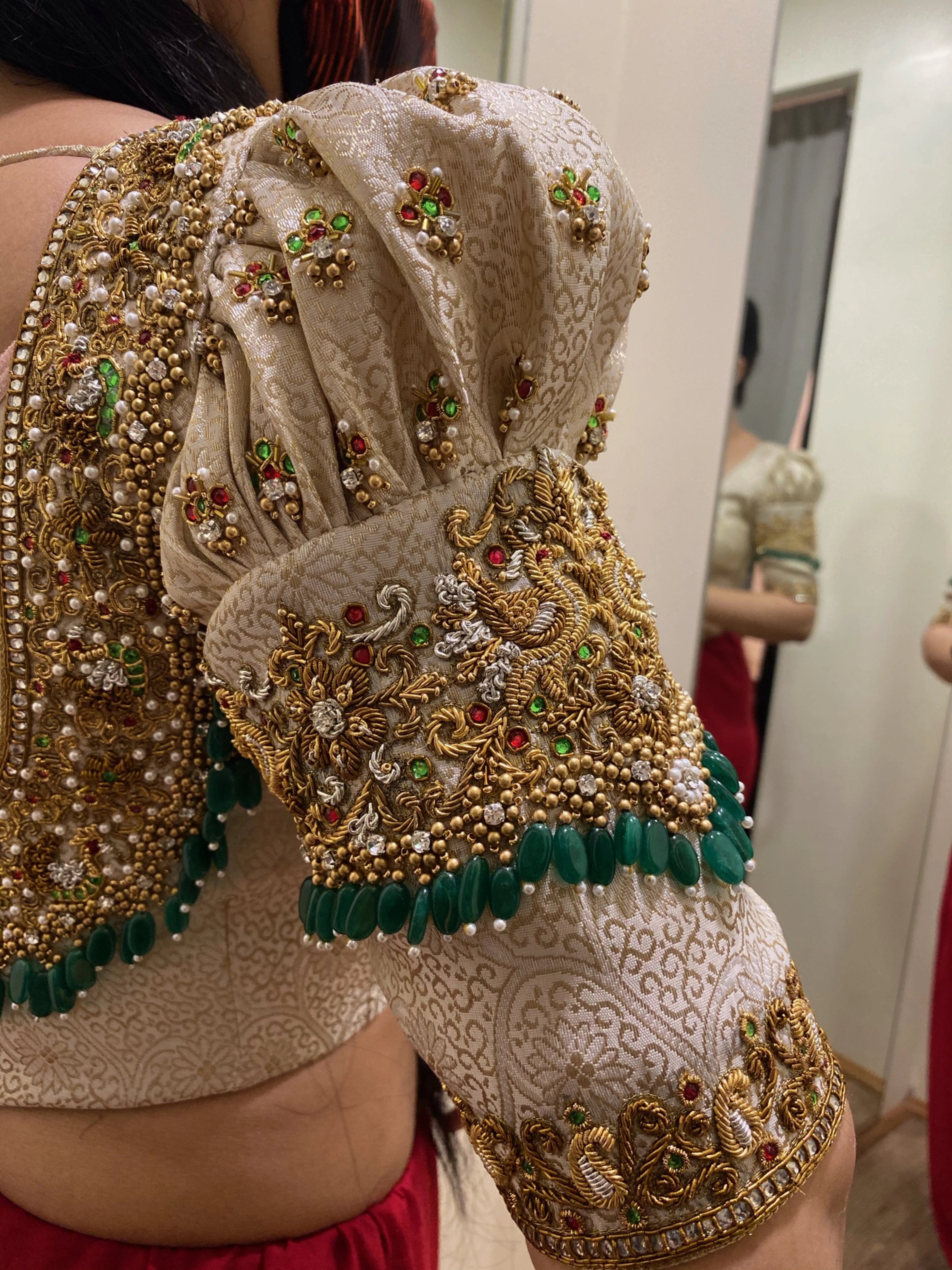 Bride Shalini from Kerala in a handcrafted ivory silk blouse embellished with beads, zardozi, kemp stones & crystals by team Archana Karthick.