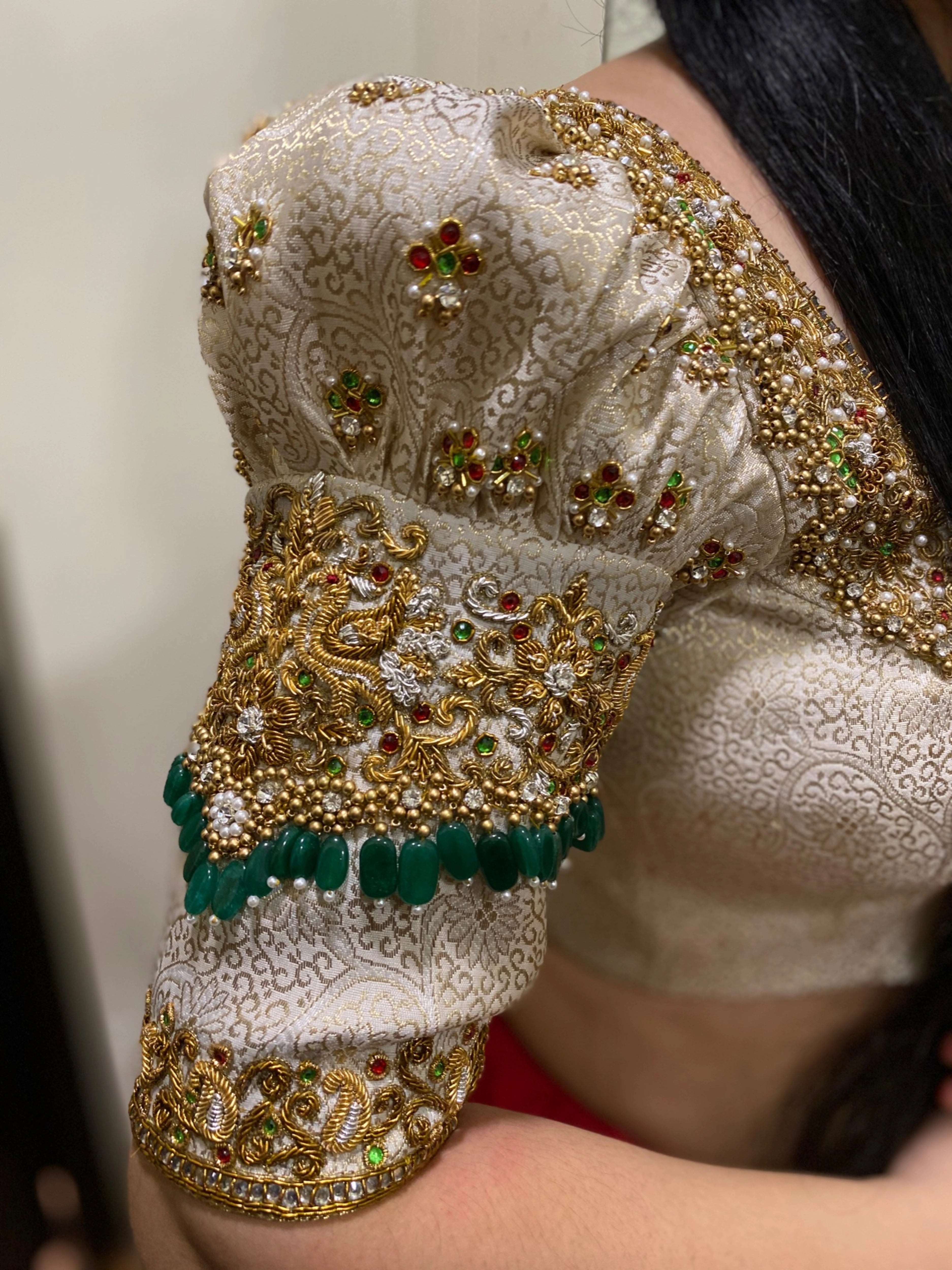 Bride Shalini from Kerala posing in a handcrafted ivory silk blouse embellished with beads, zardozi, kemp stones & crystals by team Archana Karthick.