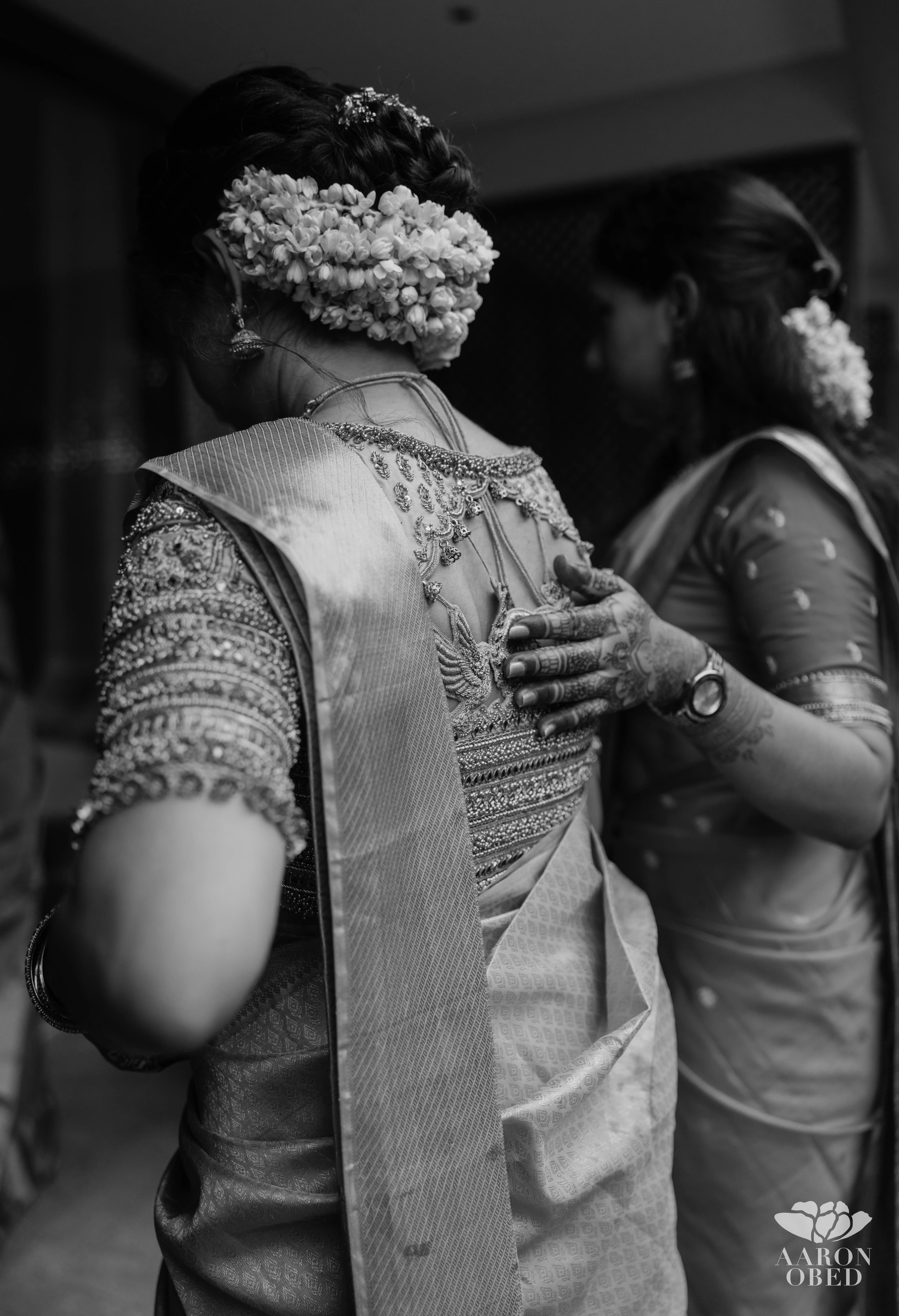 Bride Sharon Jacob in a black and white photo in a pink silk blouse, intricately handcrafted with zardozi, stones, sequins and beads by team Archana Karthick.