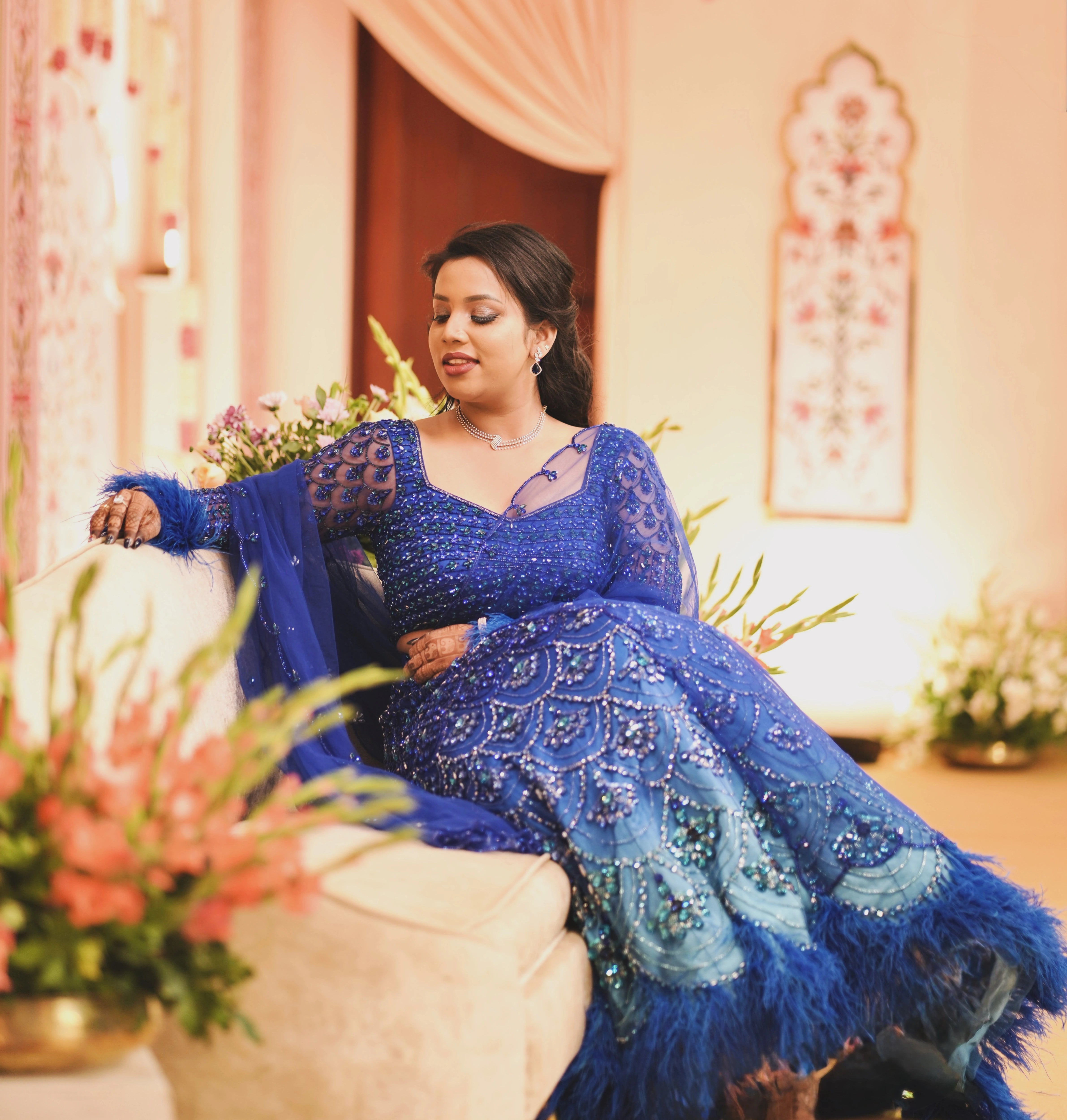 Bride Sharon posing in a peacock themed blue lehenga by Archana Karthick