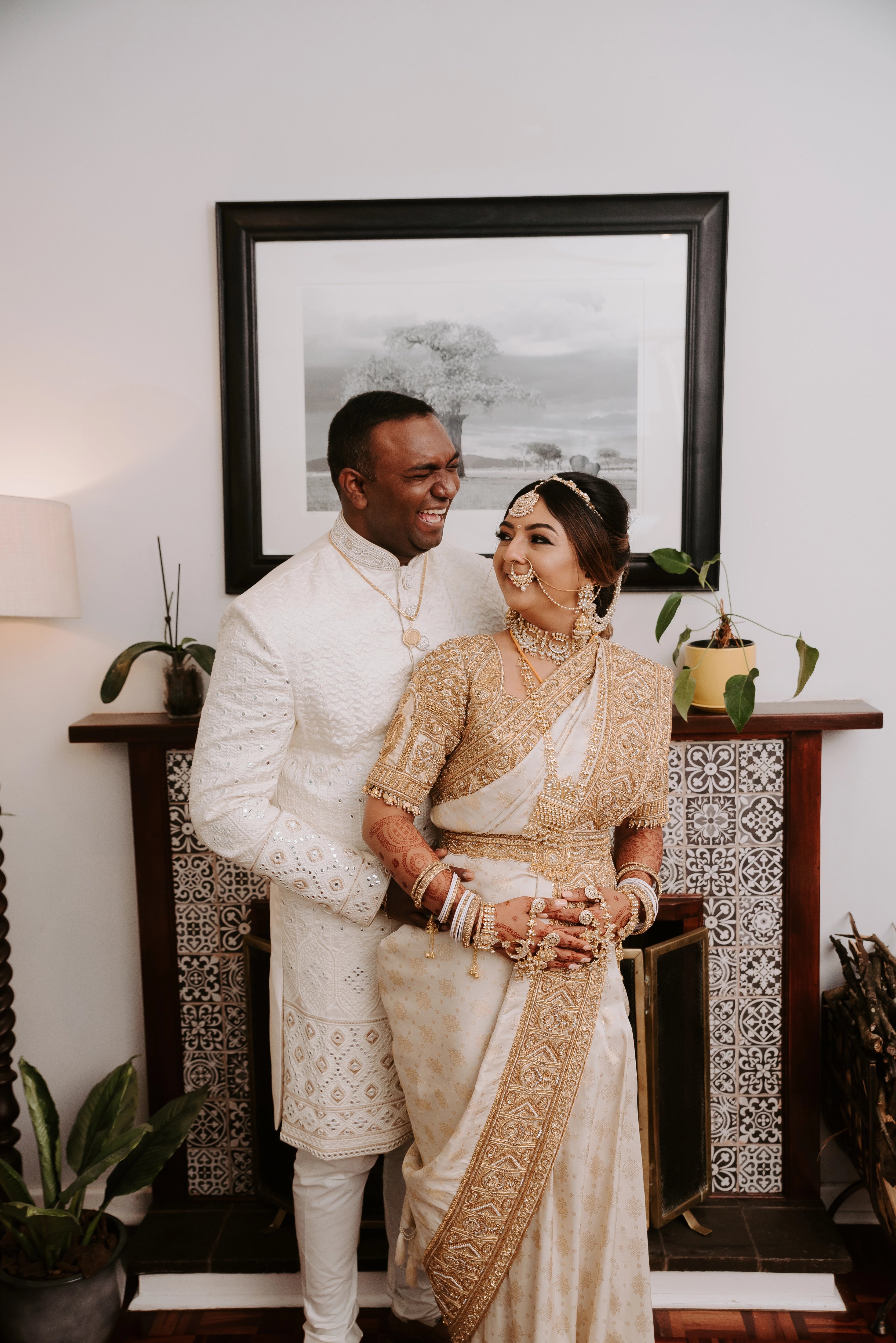 Bride Shayal having a light moment with groom in an ivory silk concept blouse & saree border, intricately handcrafted with zardozi, stones, pearls and coins by team Archana Karthick.