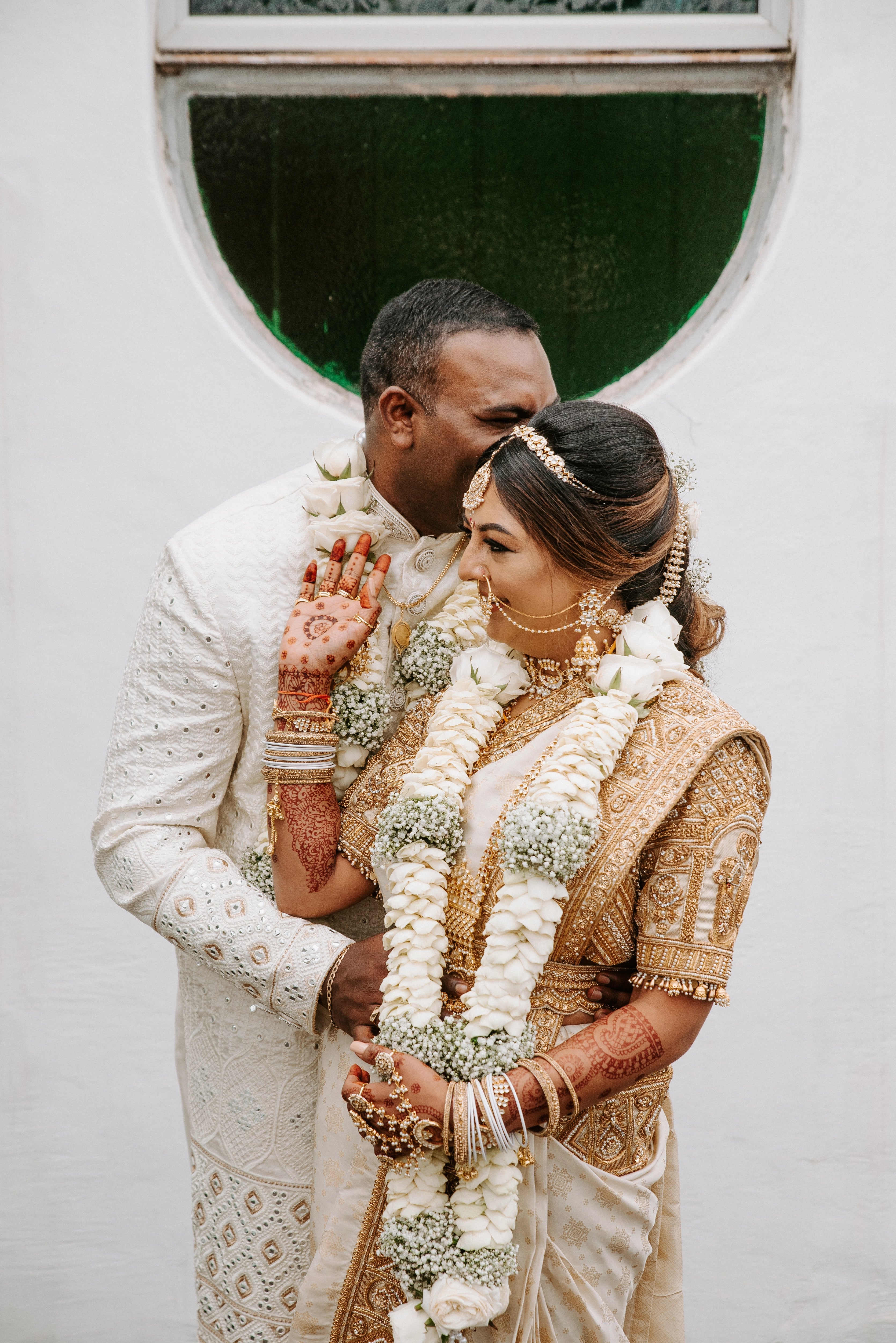Bride Shayal having an intimate moment with groom in an ivory silk concept blouse & saree border, intricately handcrafted with zardozi, stones, pearls and coins by team Archana Karthick.