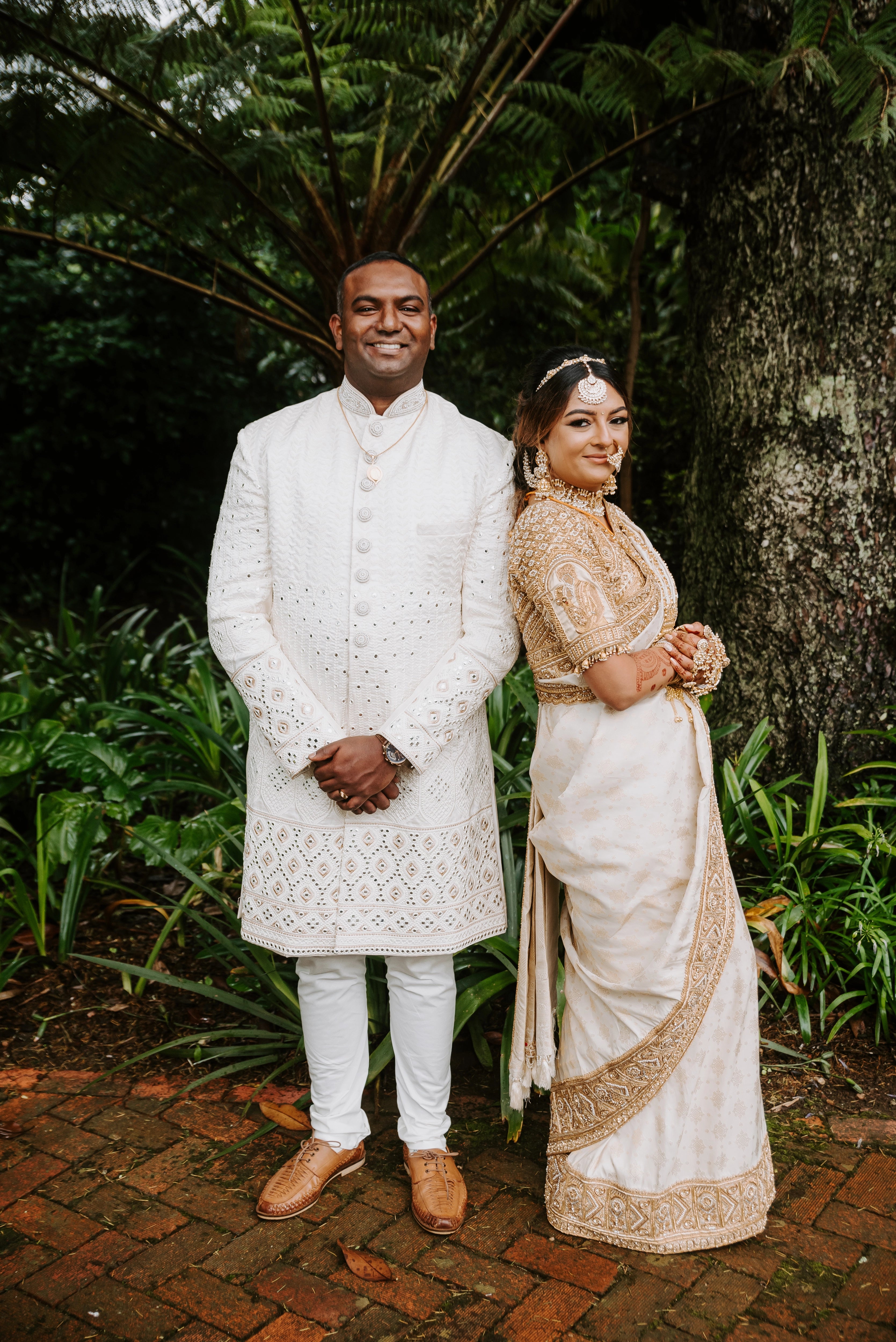 Bride Shayal leaning on groom in an ivory silk concept blouse & saree border, intricately handcrafted with zardozi, stones, pearls and coins by team Archana Karthick.