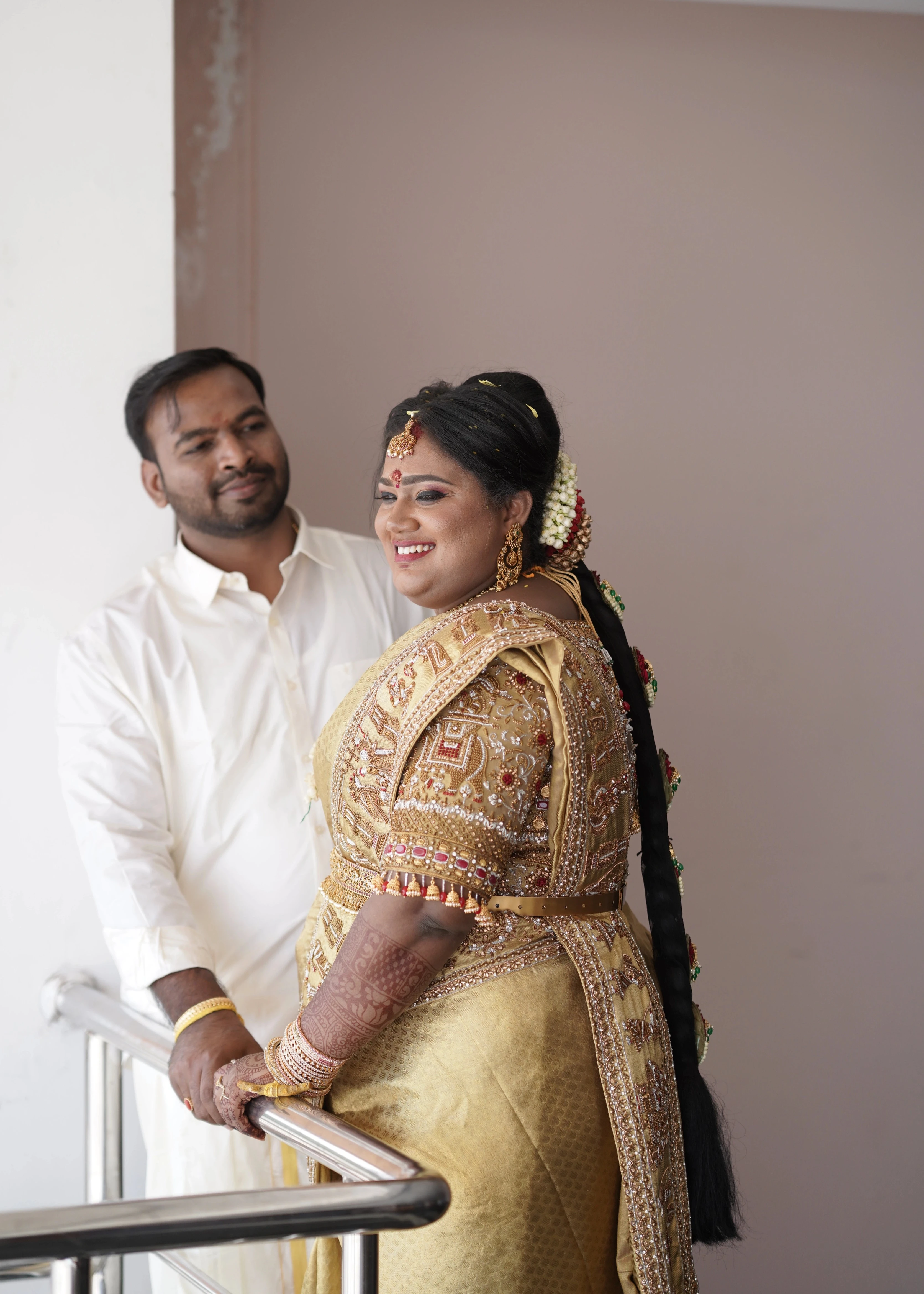 Bride Shyamaladevi smiling with groom in a gold palanquin concept silk blouse & saree border, intricately handcrafted with coins, jhumkas, zardozi etc by team Archana Karthick.