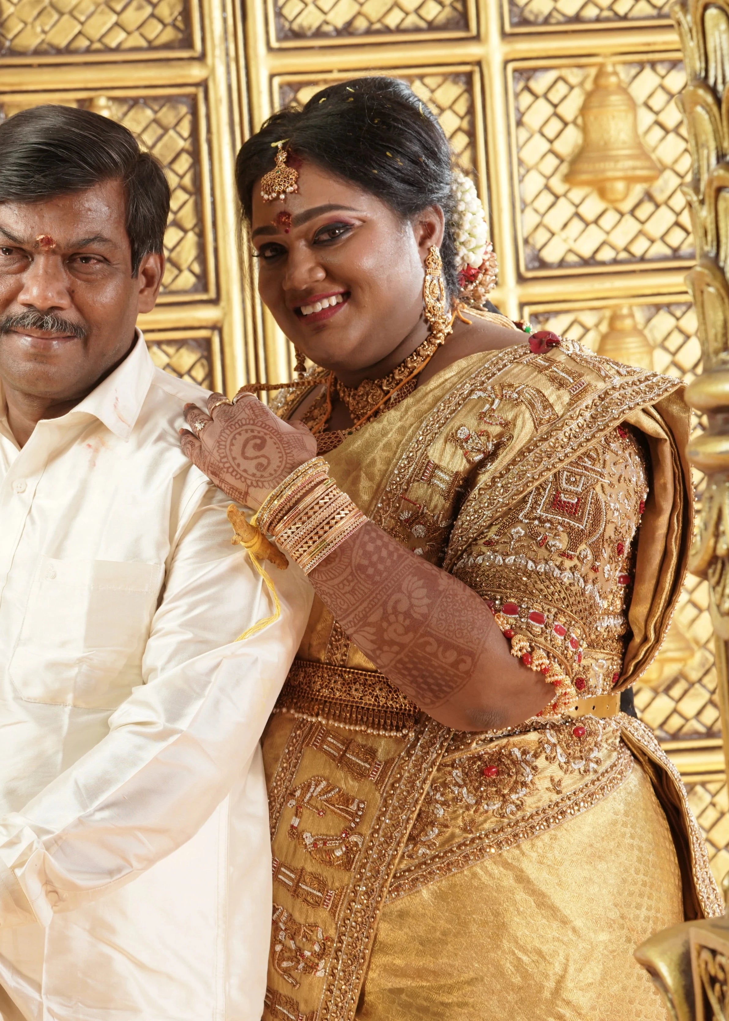 Bride Shyamaladevi smiling with her father in a gold palanquin concept silk blouse & saree border, intricately handcrafted with coins, jhumkas, zardozi etc by team Archana Karthick.