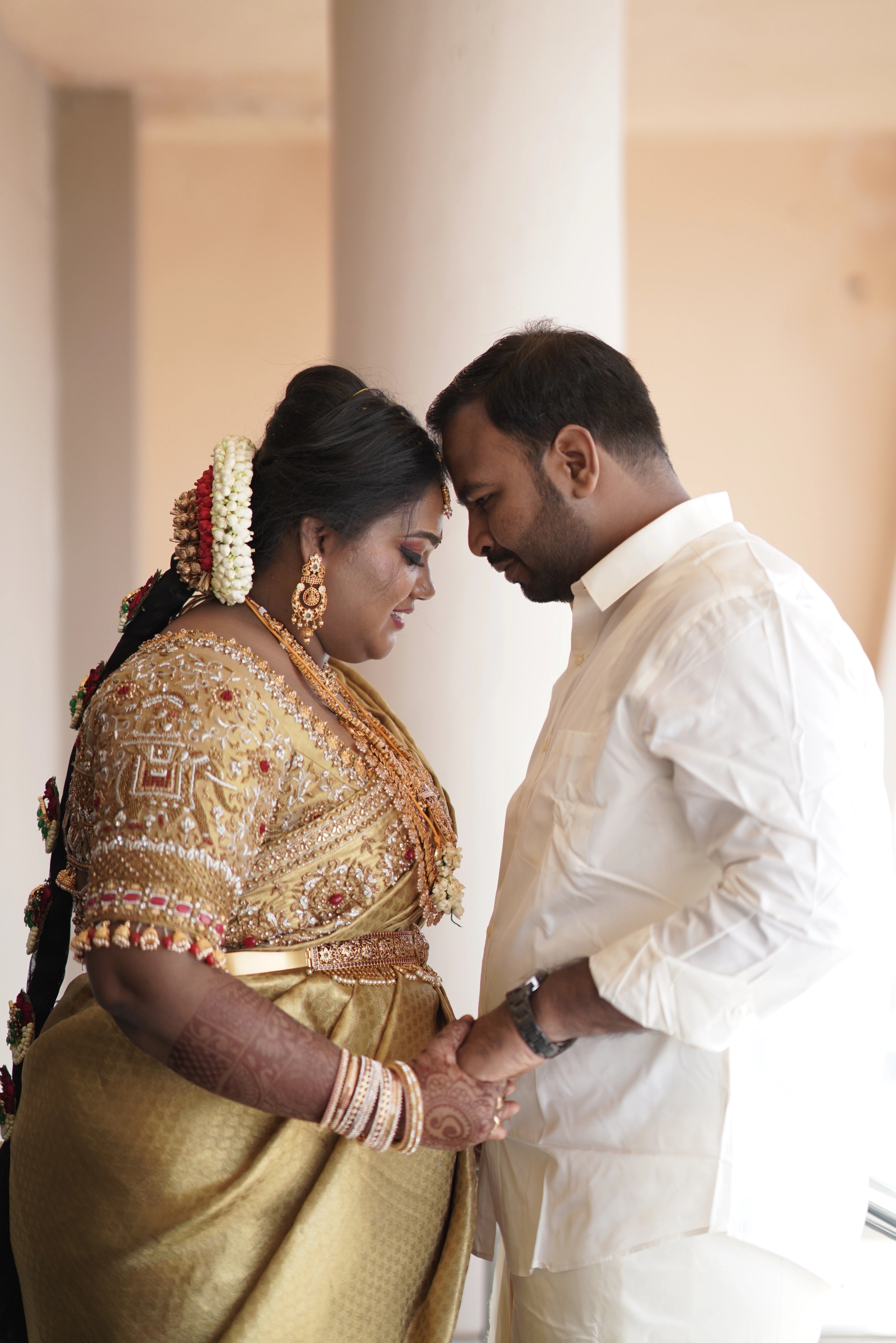 Bride Shyamaladevi with groom in a gold palanquin concept silk blouse & saree border, intricately handcrafted with coins, jhumkas, zardozi etc by team Archana Karthick.