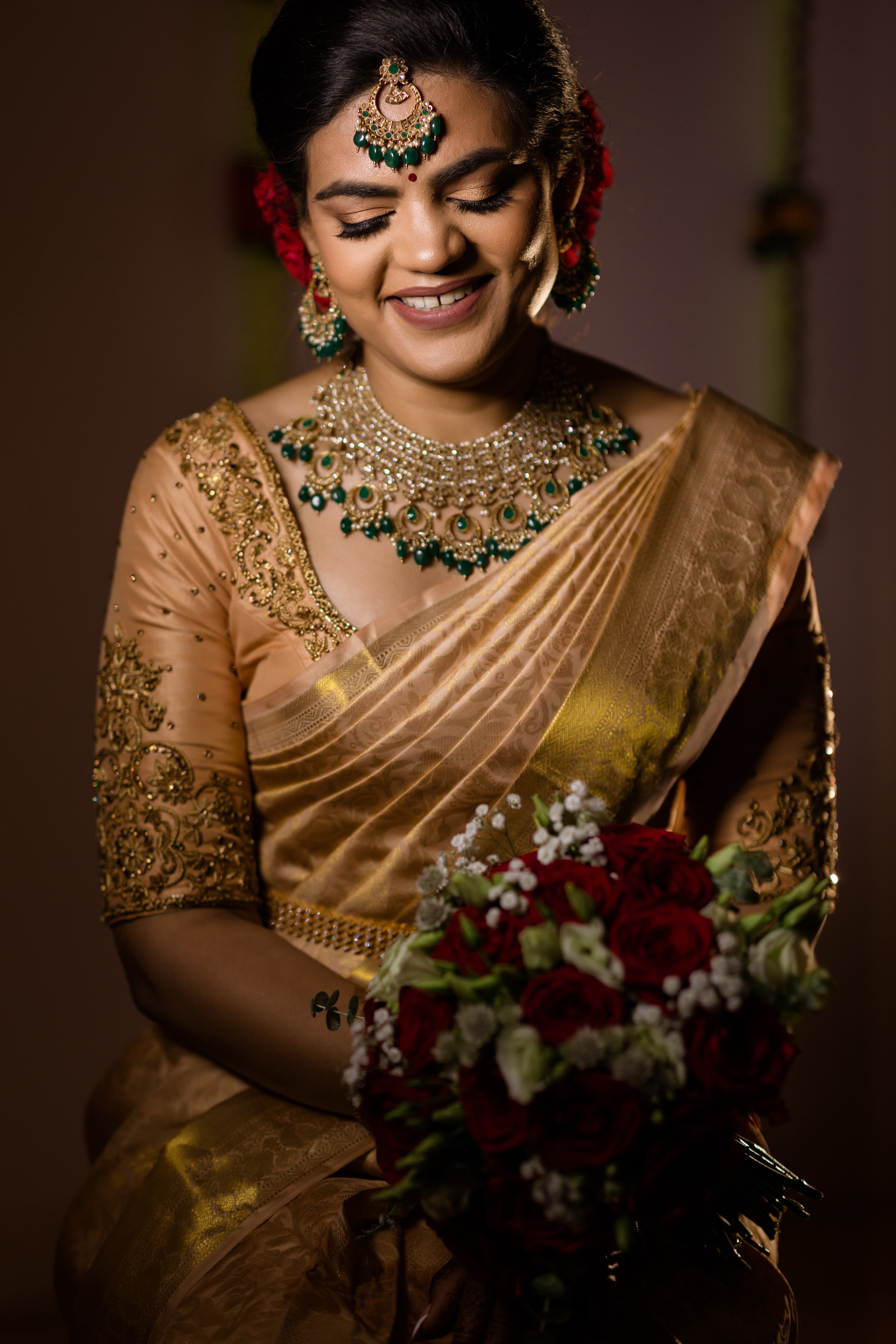 Bride Sinthuja from Middlesex, UK in a handcrafted silk blouse designed by Archana Karthick. Looking down shyly.