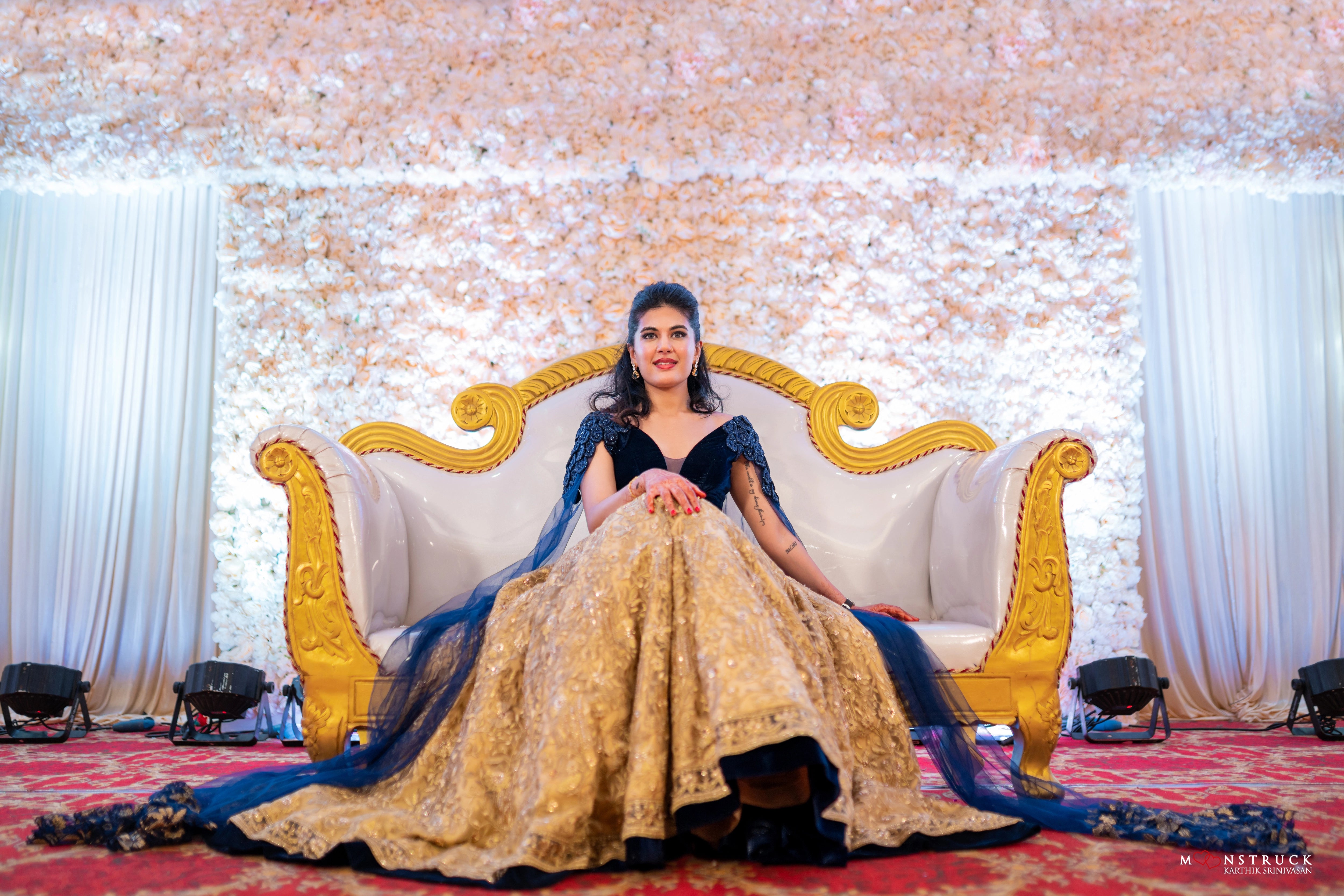Bride Sneha Murugan on stage in a midnight blue (velvet) and gold (tulle) lehenga, intricately handcrafted with zari, sequins, cutdana and stones by team Archana Karthick.