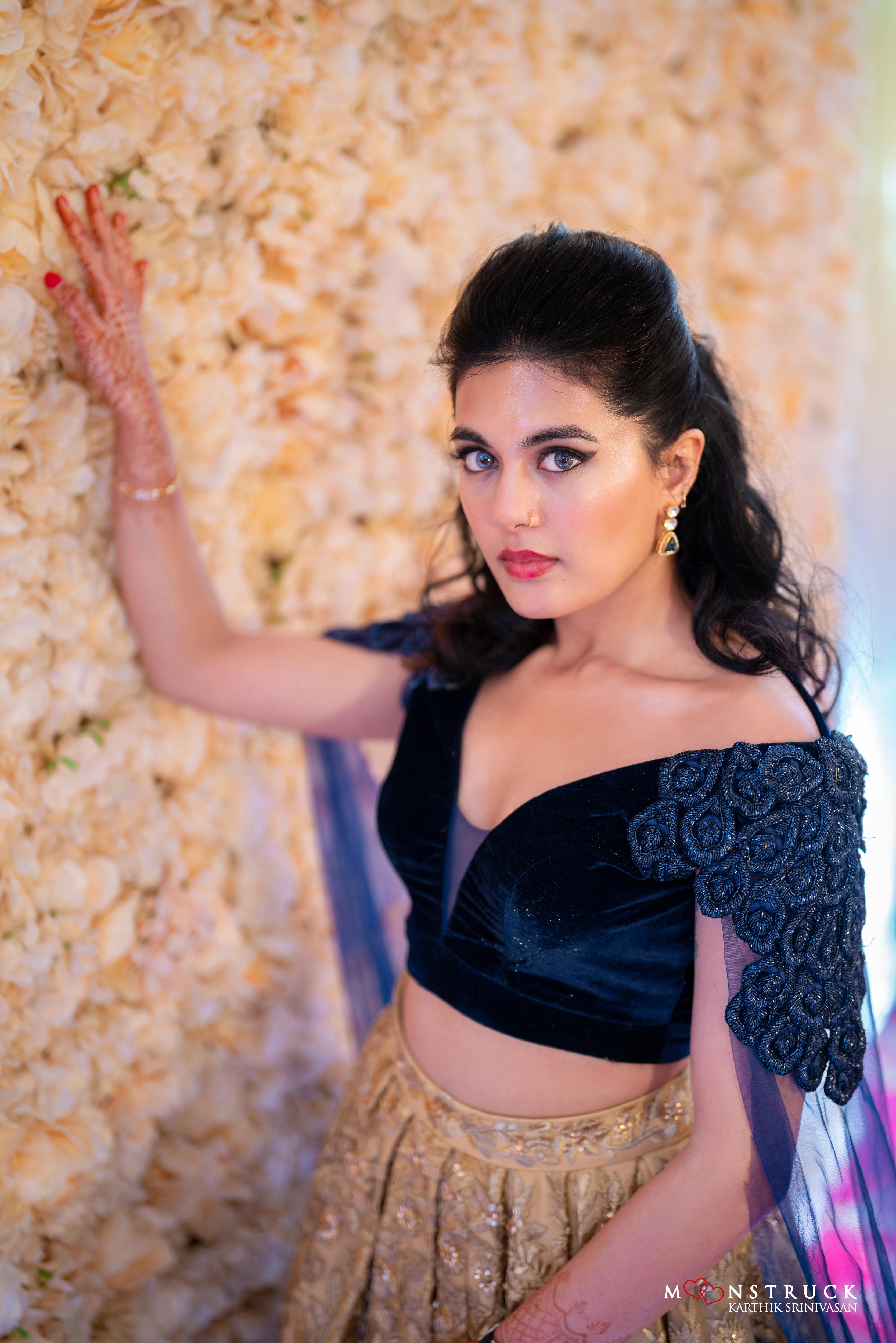 Bride Sneha Murugan posing for photoshoot in a midnight blue (velvet) and gold (tulle) lehenga, intricately handcrafted with zari, sequins, cutdana and stones by team Archana Karthick.