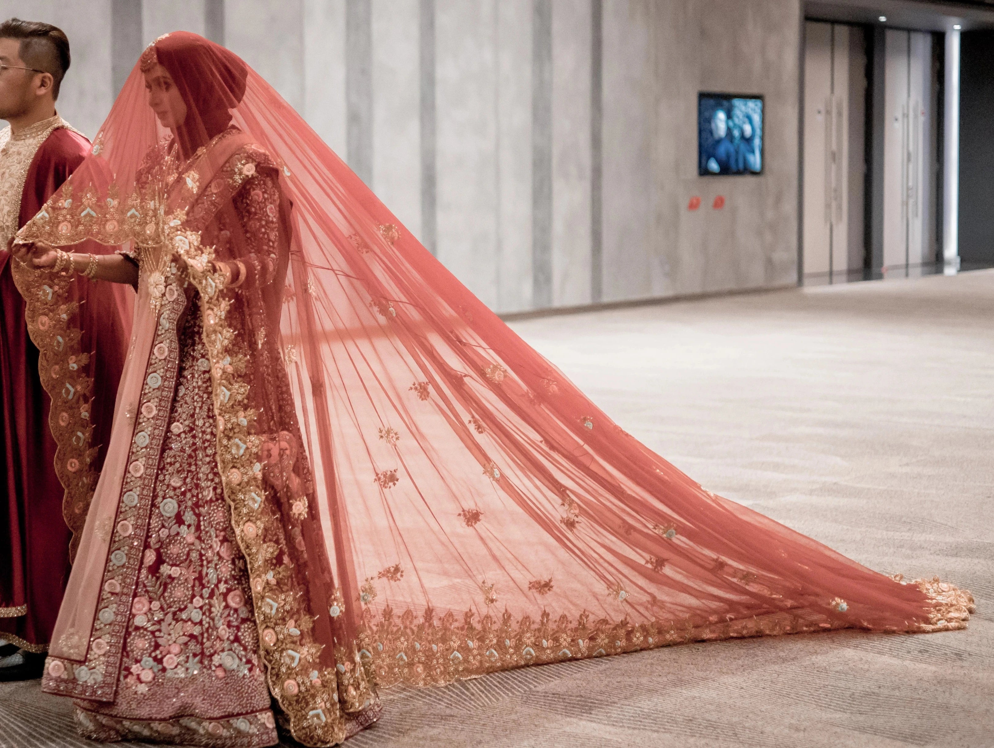Bride Syaza from Malaysia with groom in a maroon tulle veil, intricately handcrafted with zardozi, beads, sequins, stones and resham by team Archana Karthick.