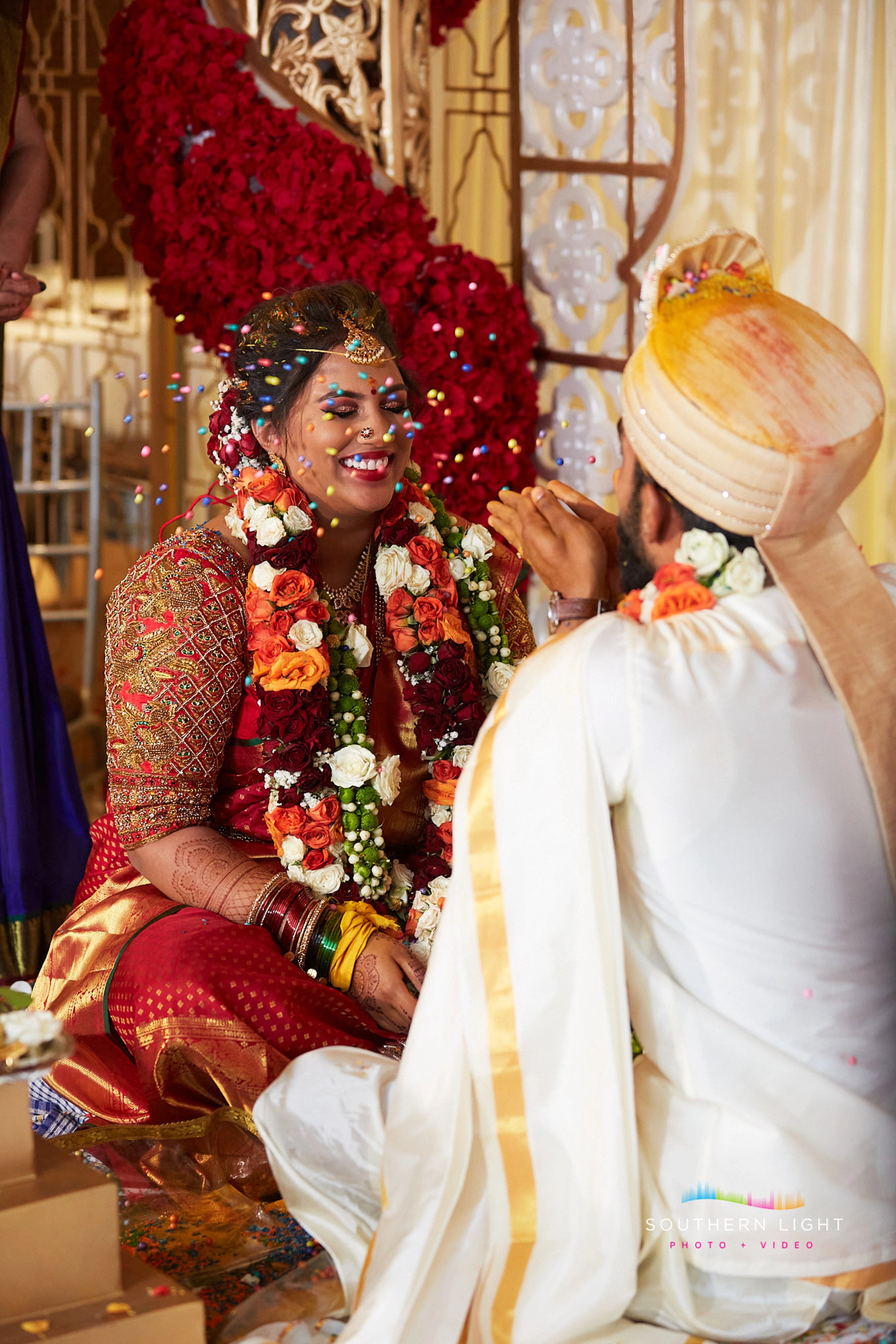 Bride Thena from Australia posing with groom in a red silk blouse by Archana Karthick