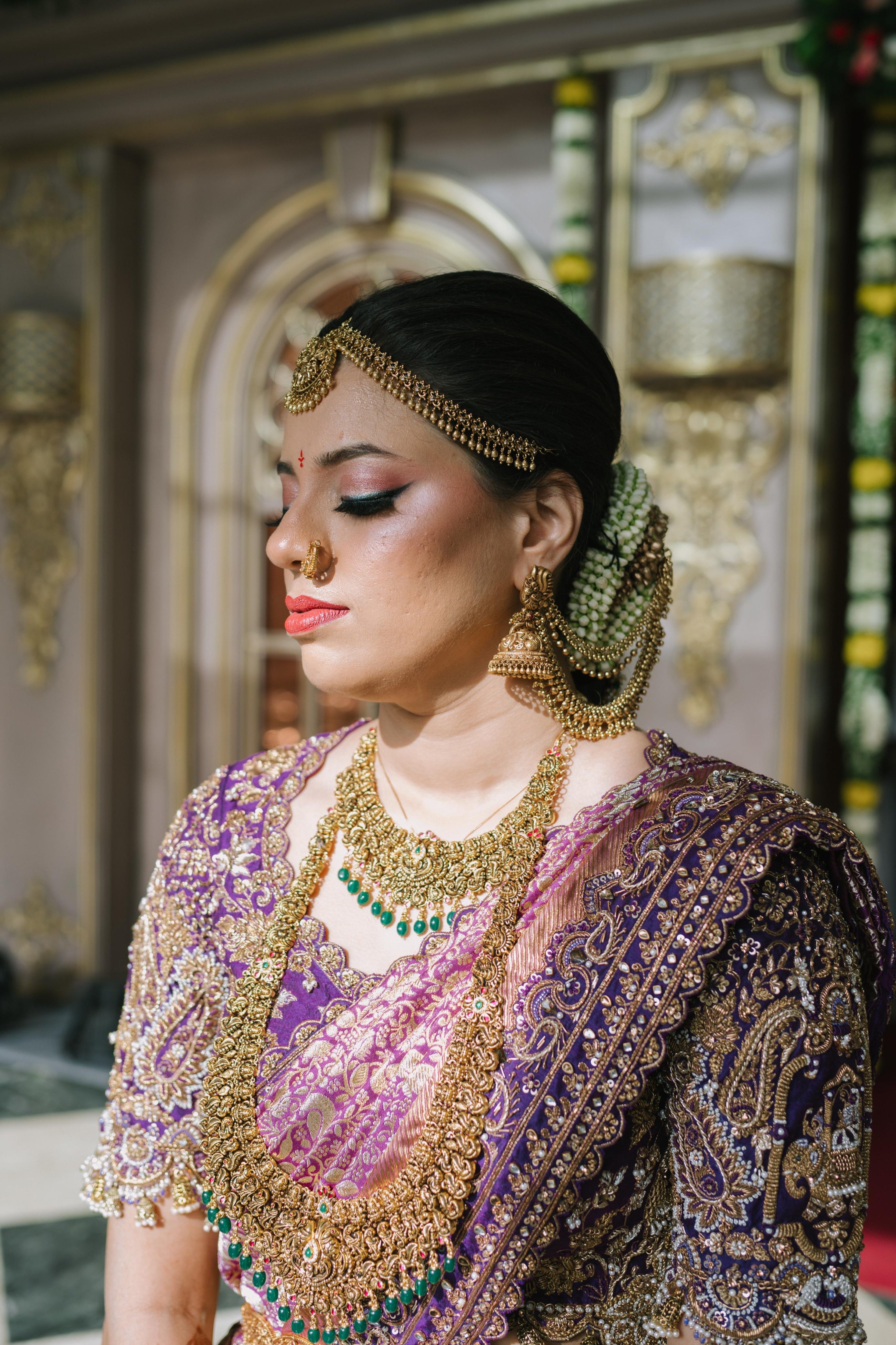 Bride Urmila posing elegantly in a closeup shot of her handcrafted blouse and saree border for her wedding muhurtham designed by Archana Karthick. Blouse sleeves and saree border detailing captured well.