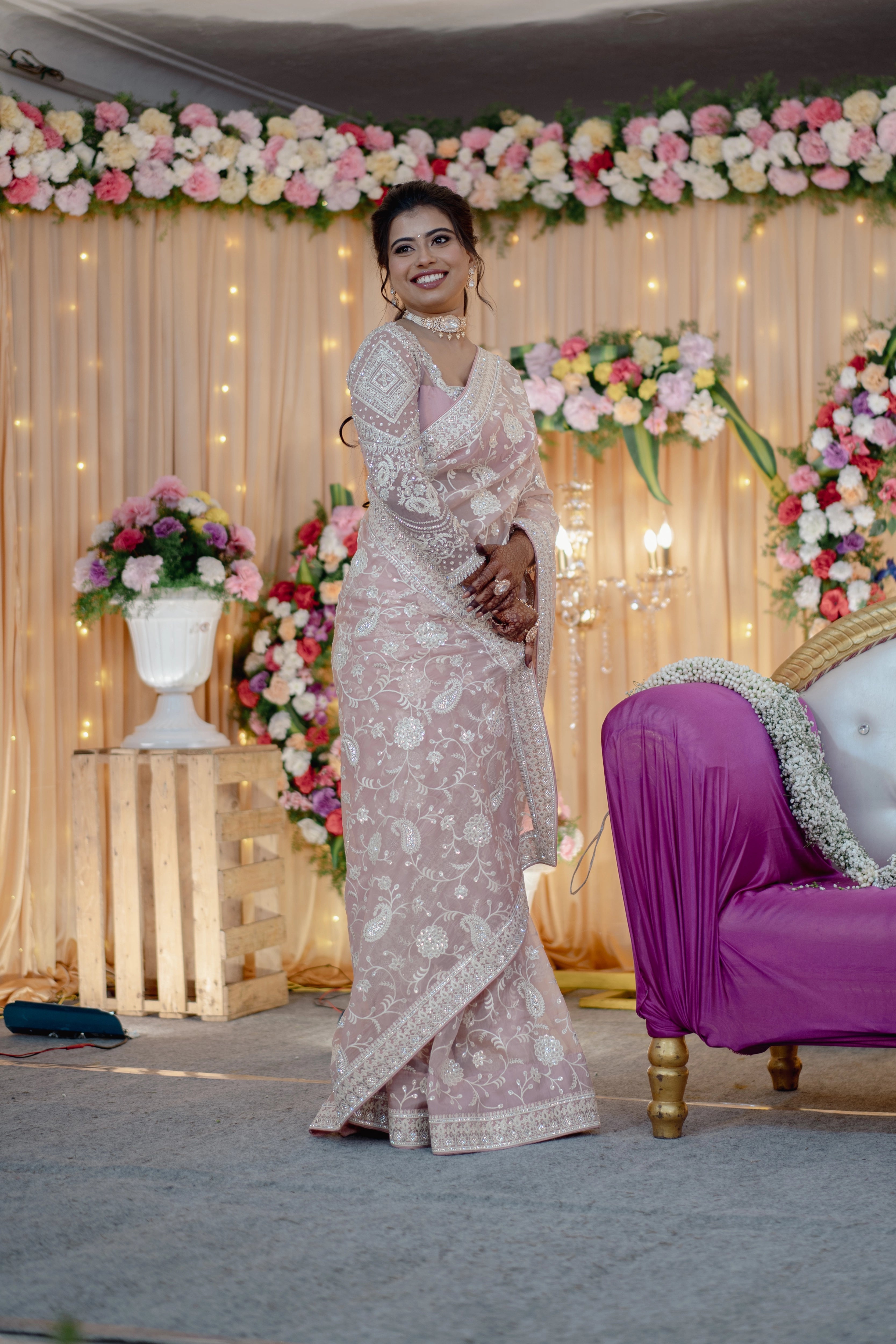 Bride Vidhira on the stage in a soft blush tulle blouse for her reception, handcrafted with rhinestones, resham and crystals by team Archana Karthick.