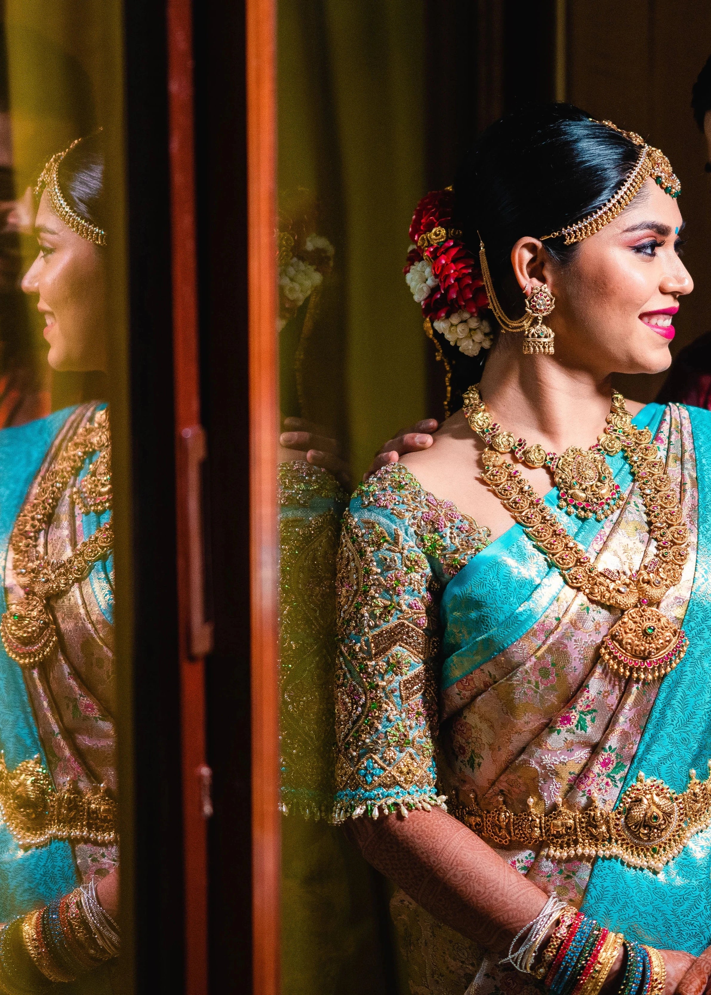 Bride Vidya D posing with groom in a powder blue silk blouse, handcrafted with beads, zardozi, kundan, resham, stones and crystals by team Archana Karthick.