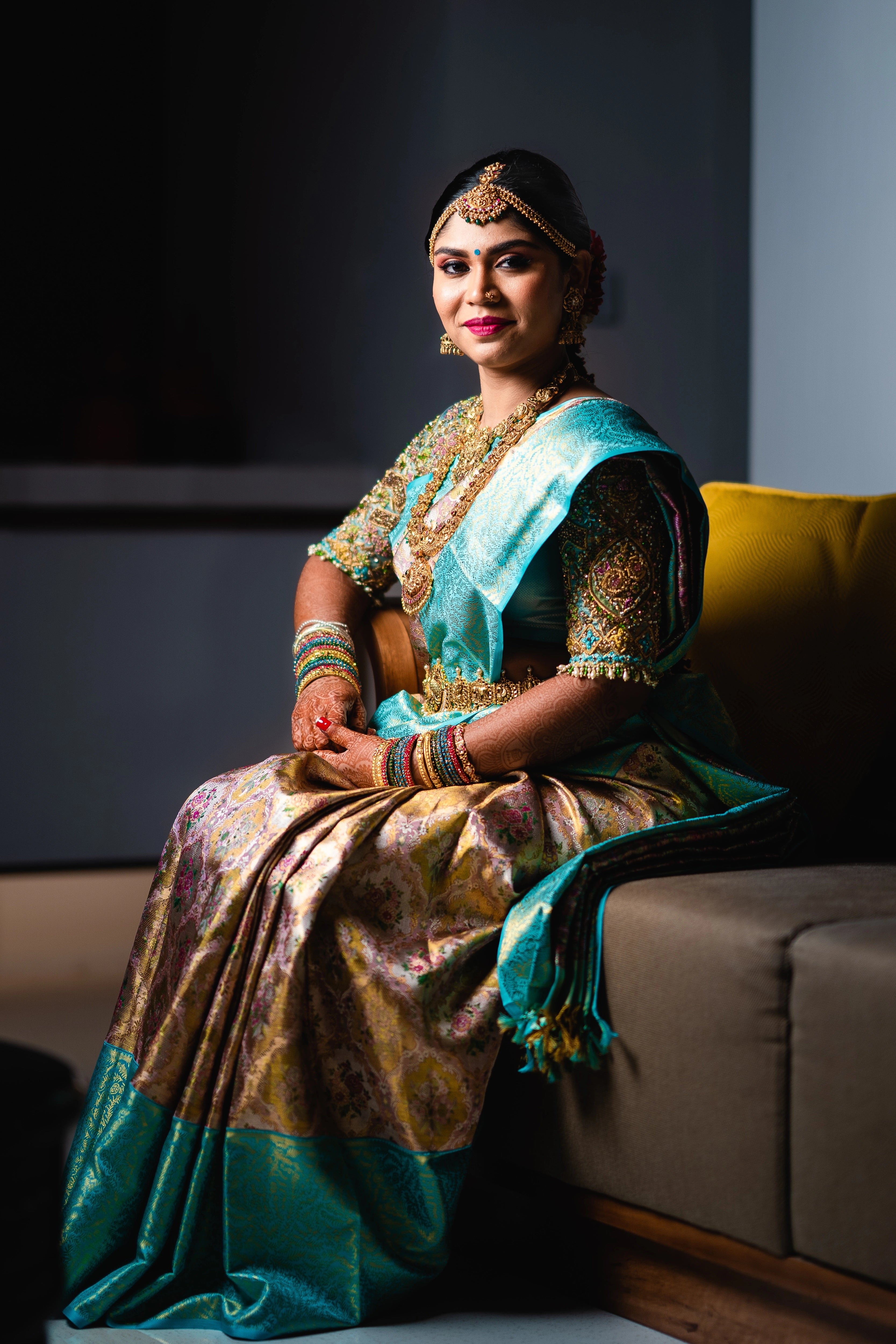 Bride Vidya D smiling in a powder blue silk blouse, handcrafted with beads, zardozi, kundan, resham, stones and crystals by team Archana Karthick.