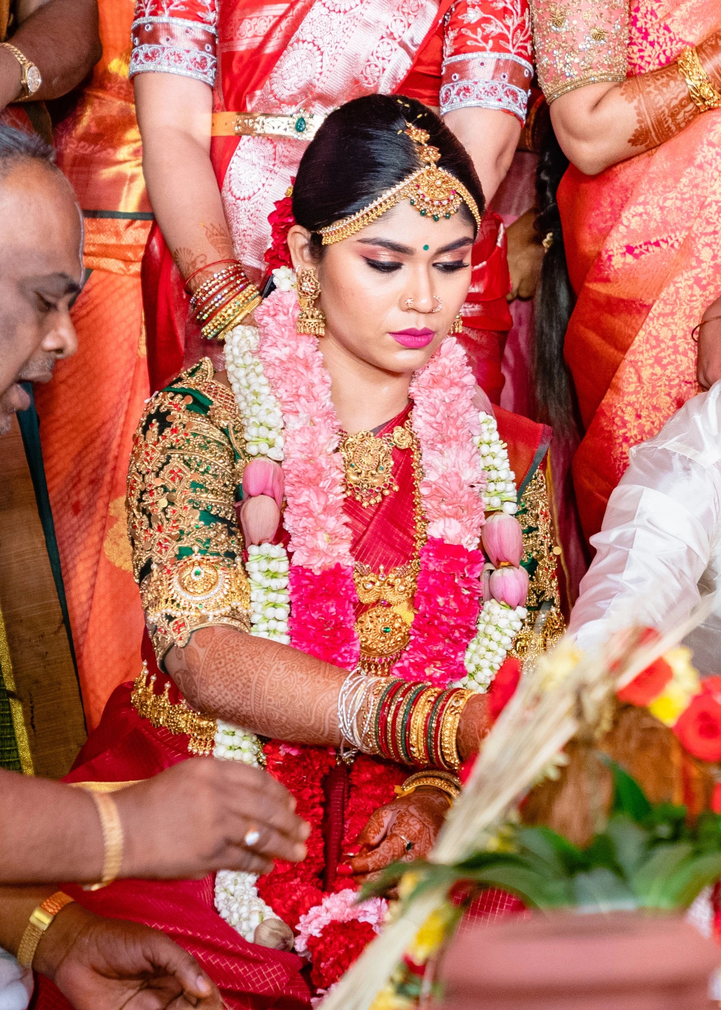 Bride Vidya D with garland in a bottle green silk blouse, handcrafted with beads, zardozi, kundan, resham, stones and coins by team Archana Karthick.
