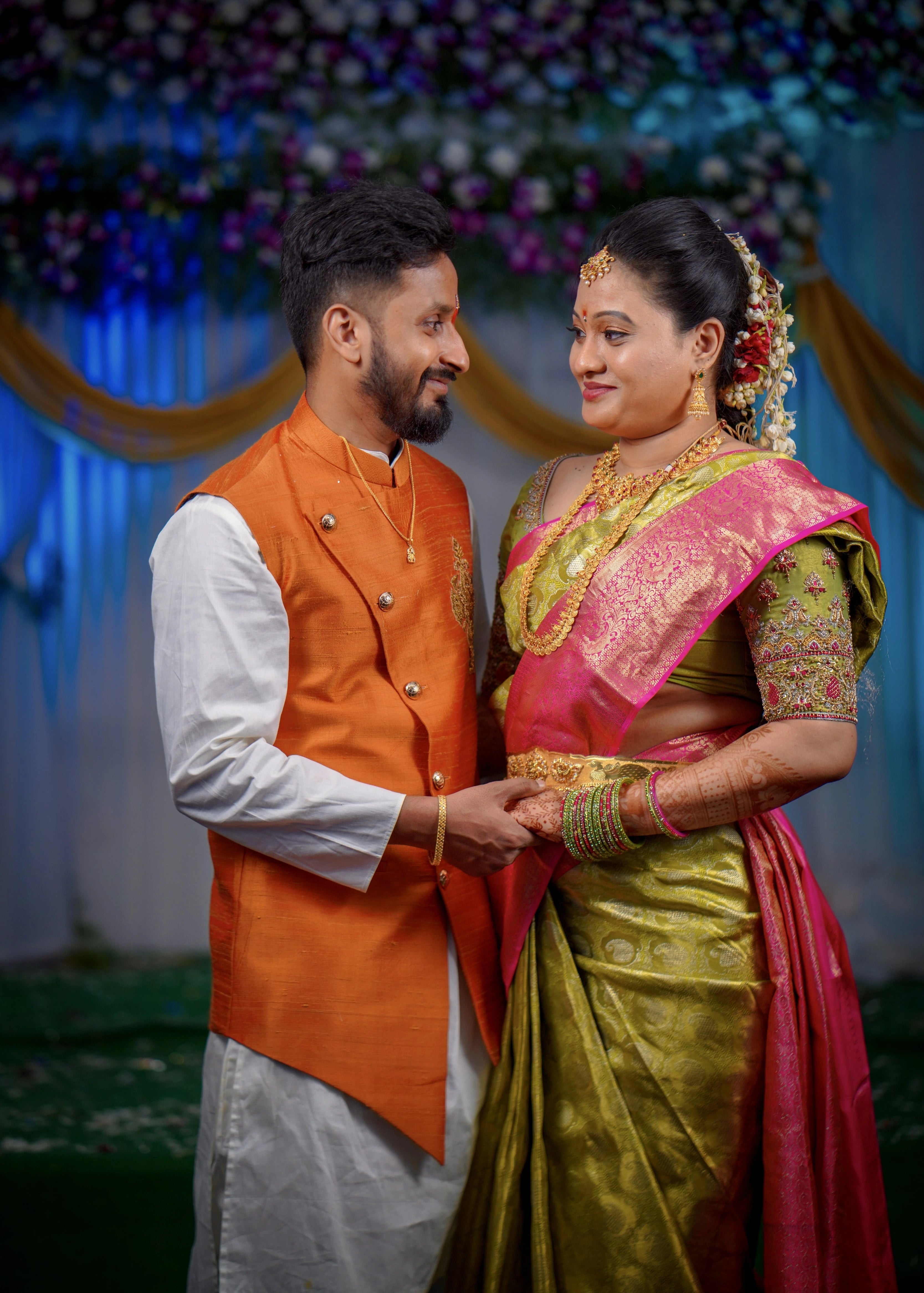 Bride and groom from Seattle, USA hand in hand in a handcrafted blouse and bandhgala set designed by Archana Karthick.