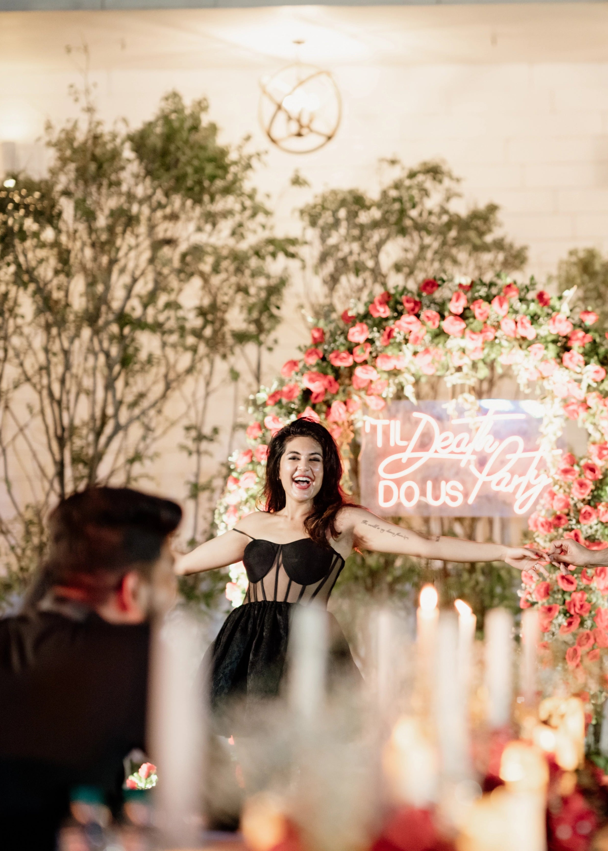 Bride celebrating with groom in a black corset dress for her cocktail party, handcrafted in raw silk, tulle and jacquard. Designed by Archana Karthick