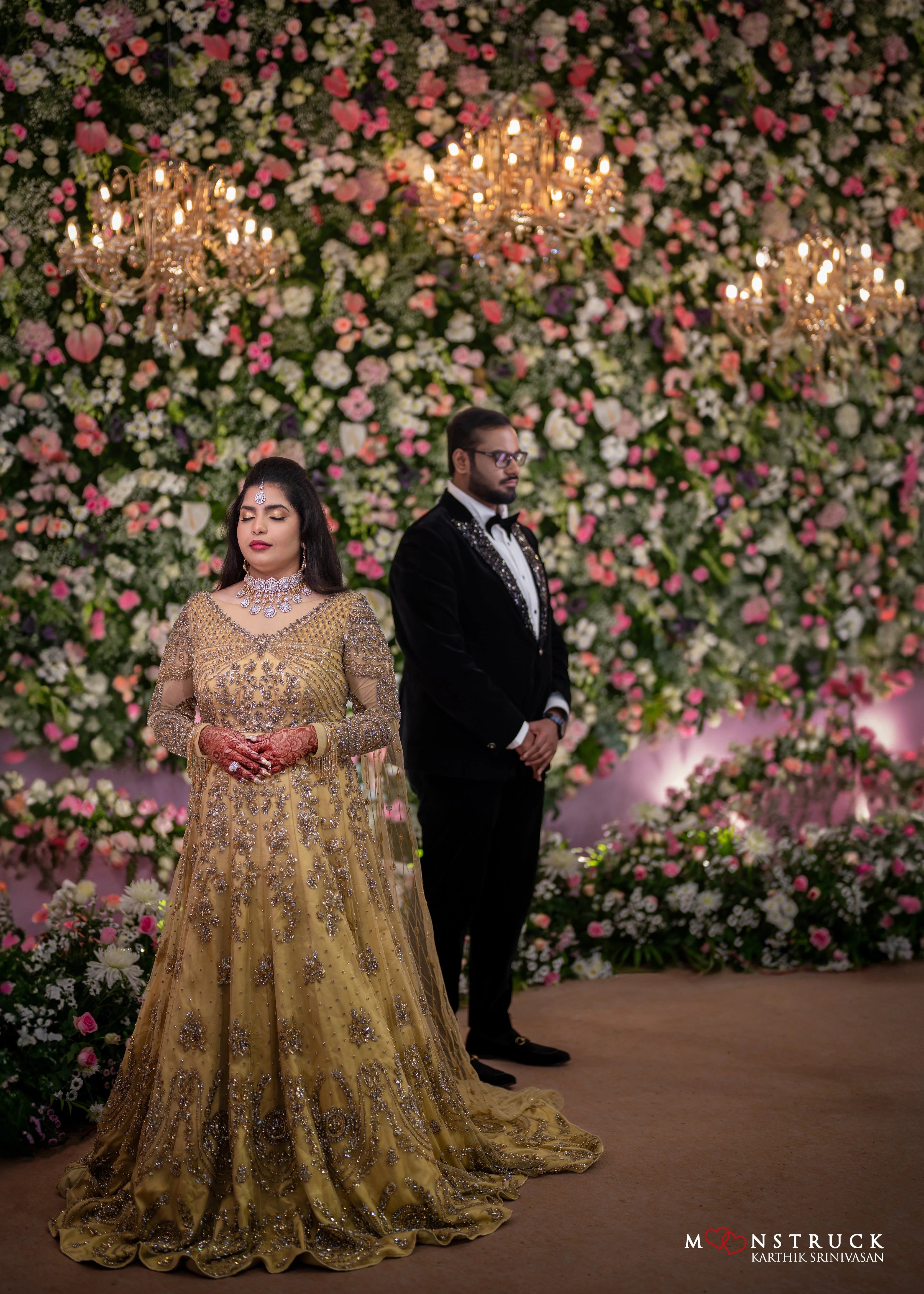 Bride closing her eyes in a gold gown in tulle designed by Archana Karthick and handcrafted with rhinestones and cut dana with floral and geometric motifs.