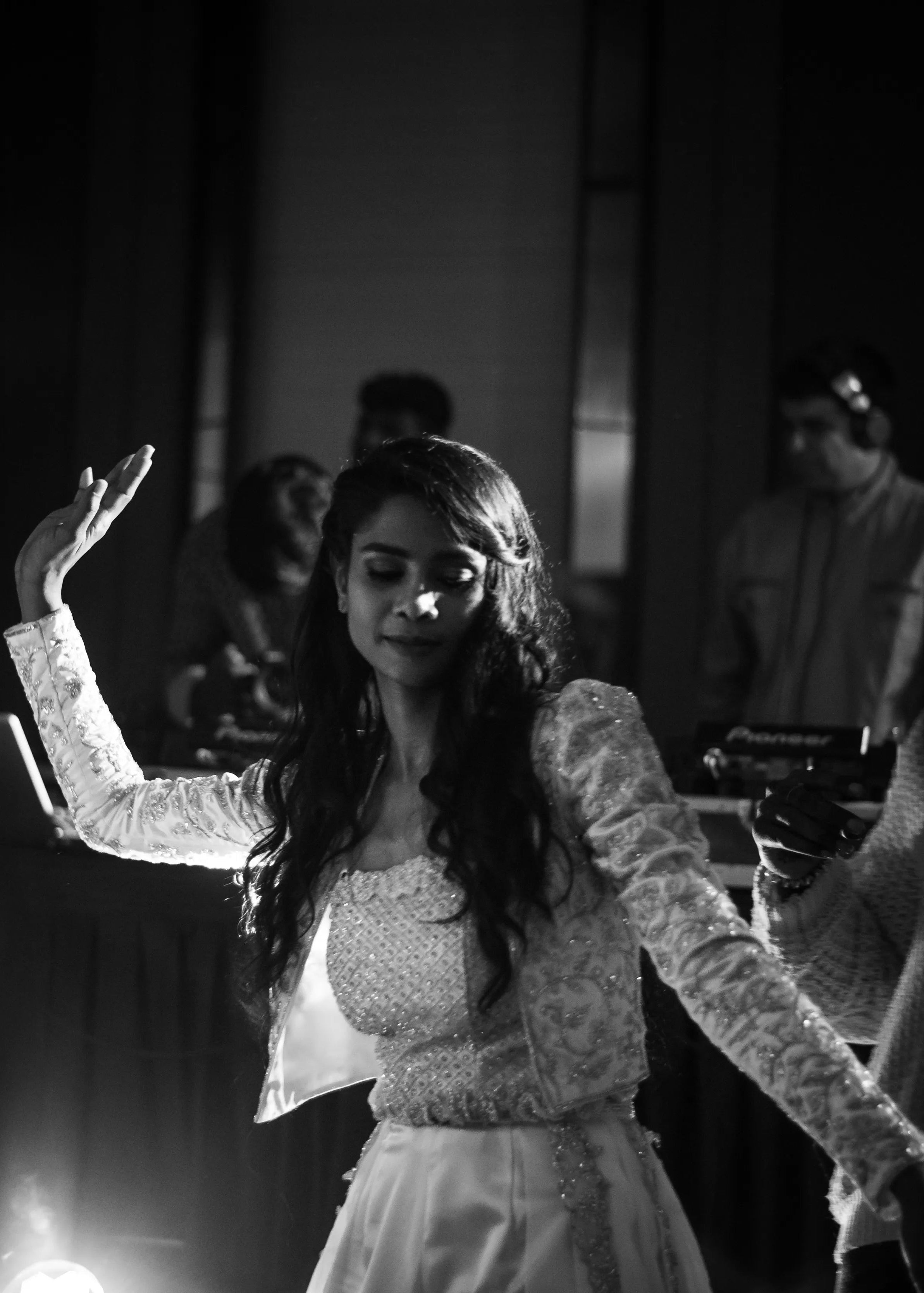 Bride dancing at her cocktail in handcrafted silver satin and organza corset outfit embellished with cut dana, pearls, stones and sequins. Designed by Archana Karthick