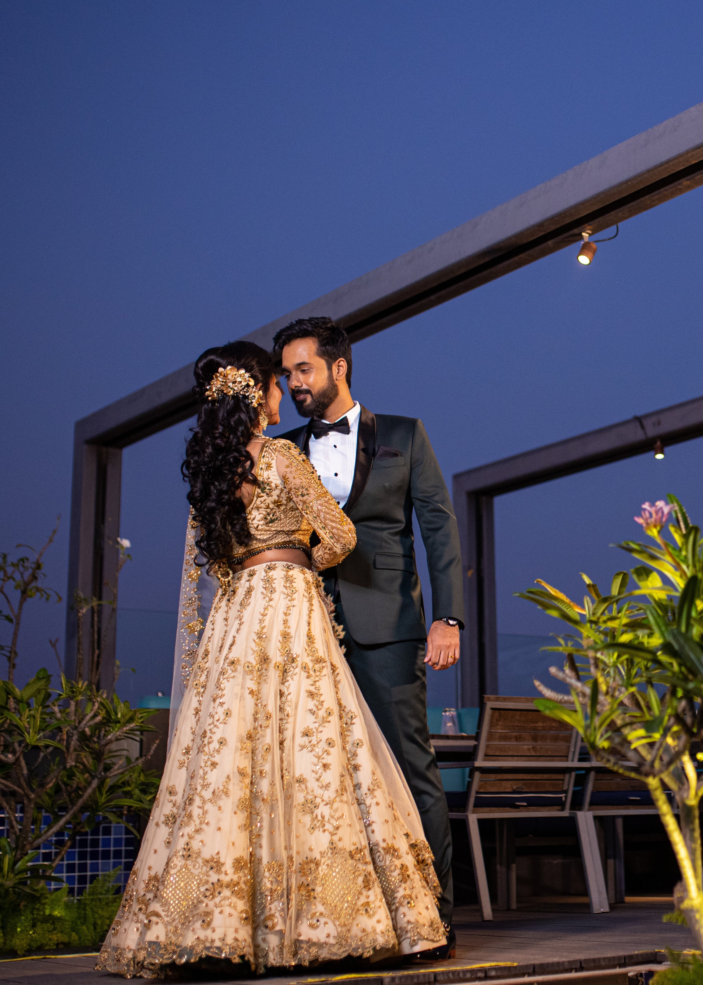 Bride dancing with groom in an ivory lehenga in tulle with cut worked dupatta and handcrafted intricately with stones, zardozi, reshams knot work, beads and cutdanas. Designed by Archana Karthick