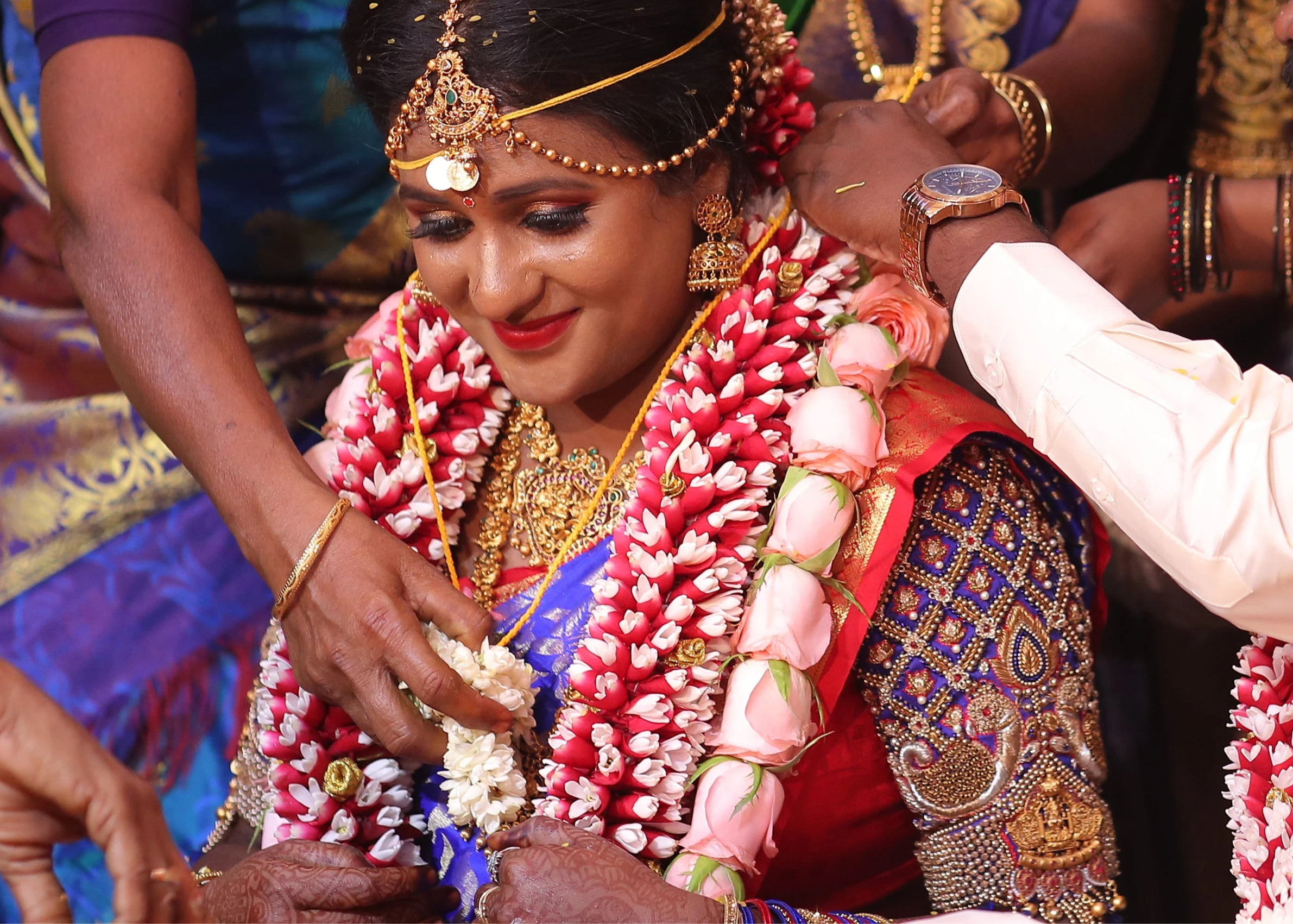 Bride emotional in a concept peacock blouse in blue and red silk, handcrafted with zardozi, beads, resham knot work and goddess pendant on sleeves.