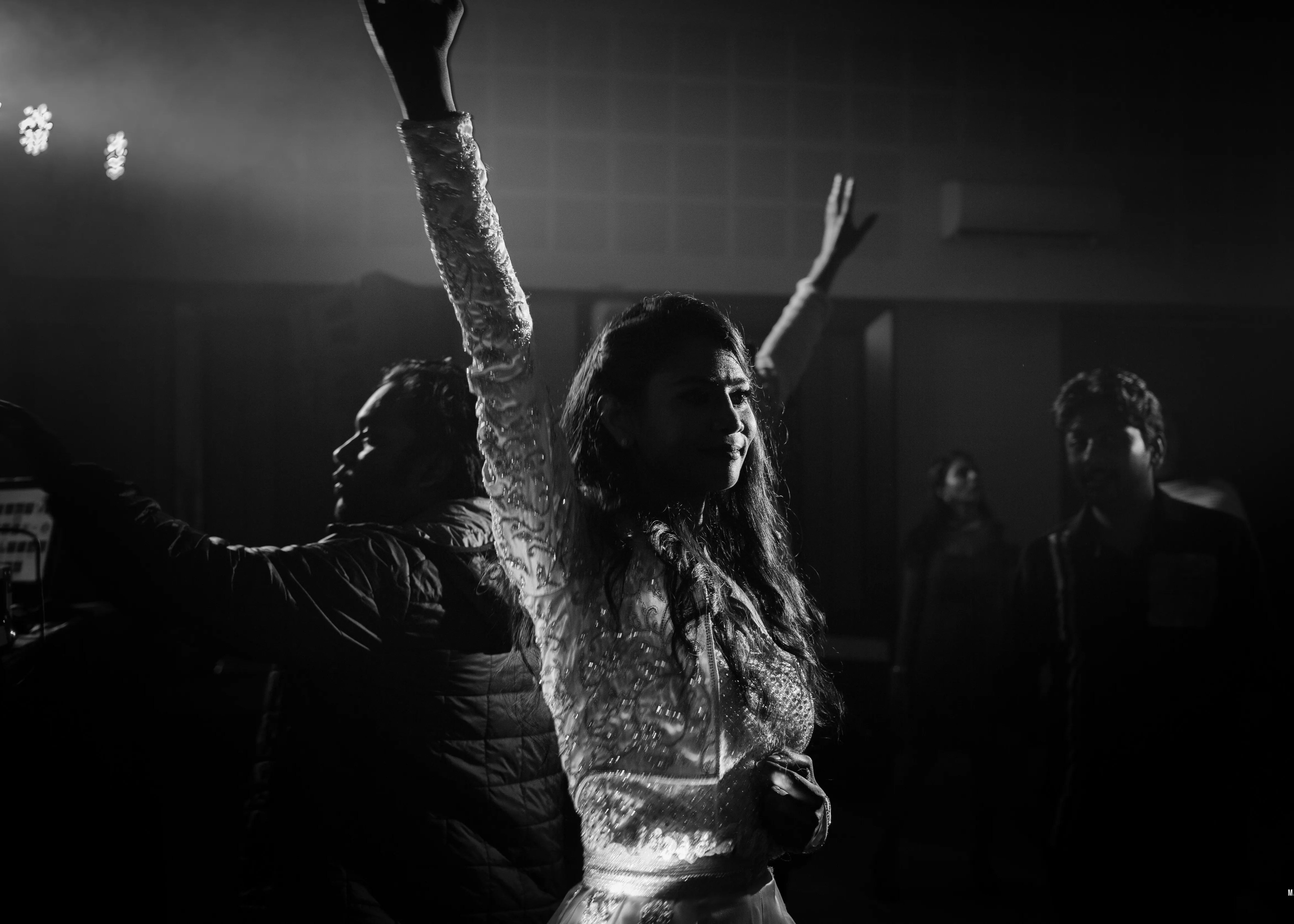 Bride enjoying at her pre-wedding cocktail party in a handcrafted silver satin and organza corset outfit embellished with cut dana, pearls, stones and sequins, designed by Archana Karthick