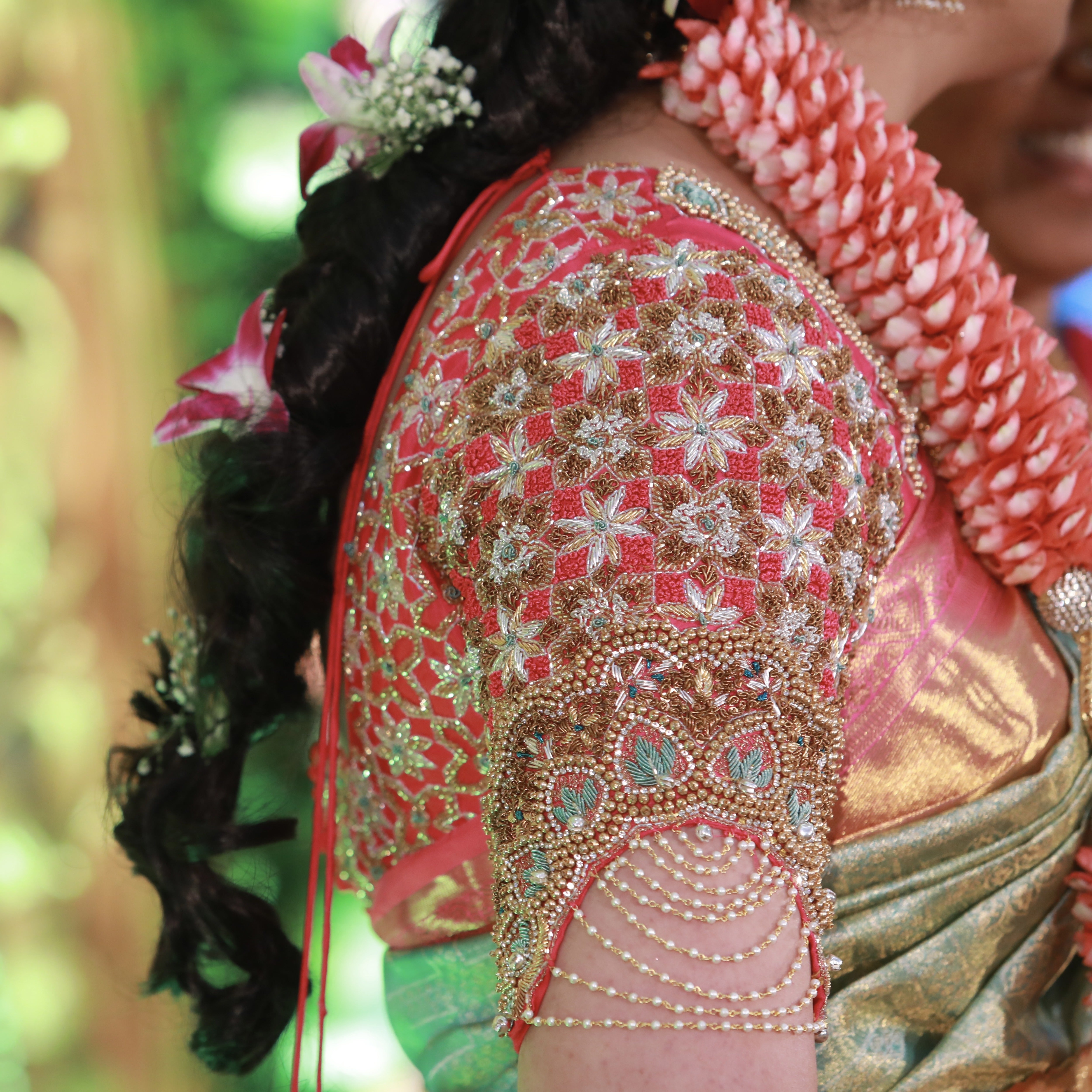 Bride for her engagement in pink raw silk blouse designed by Archana Karthick. The sleeve has been captured showcasing the intricate details.