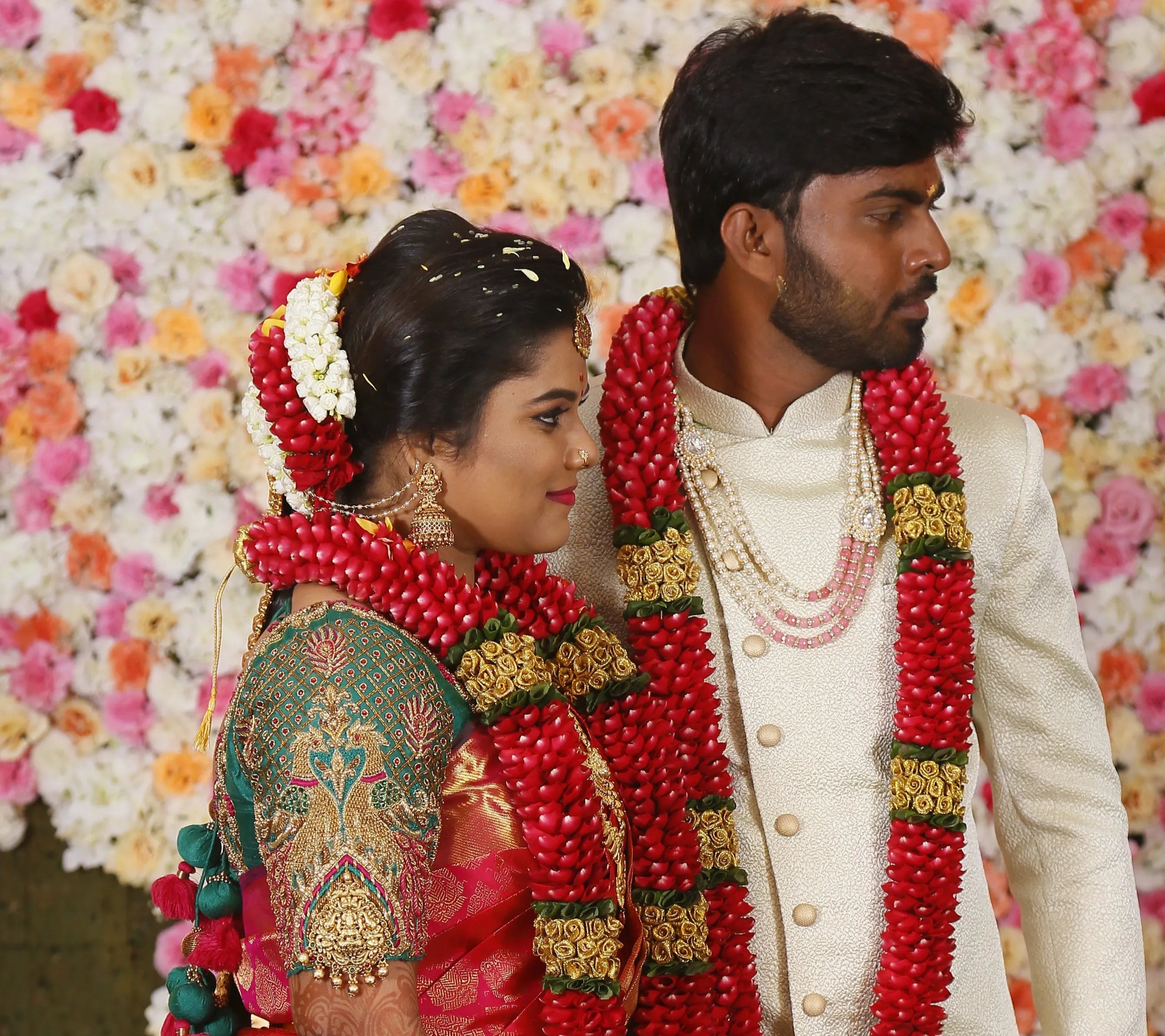 Bride from Chennai in a handcrafted peacock concept green silk blouse with goddess pendants on sleeves. Designed by Archana Karthick
