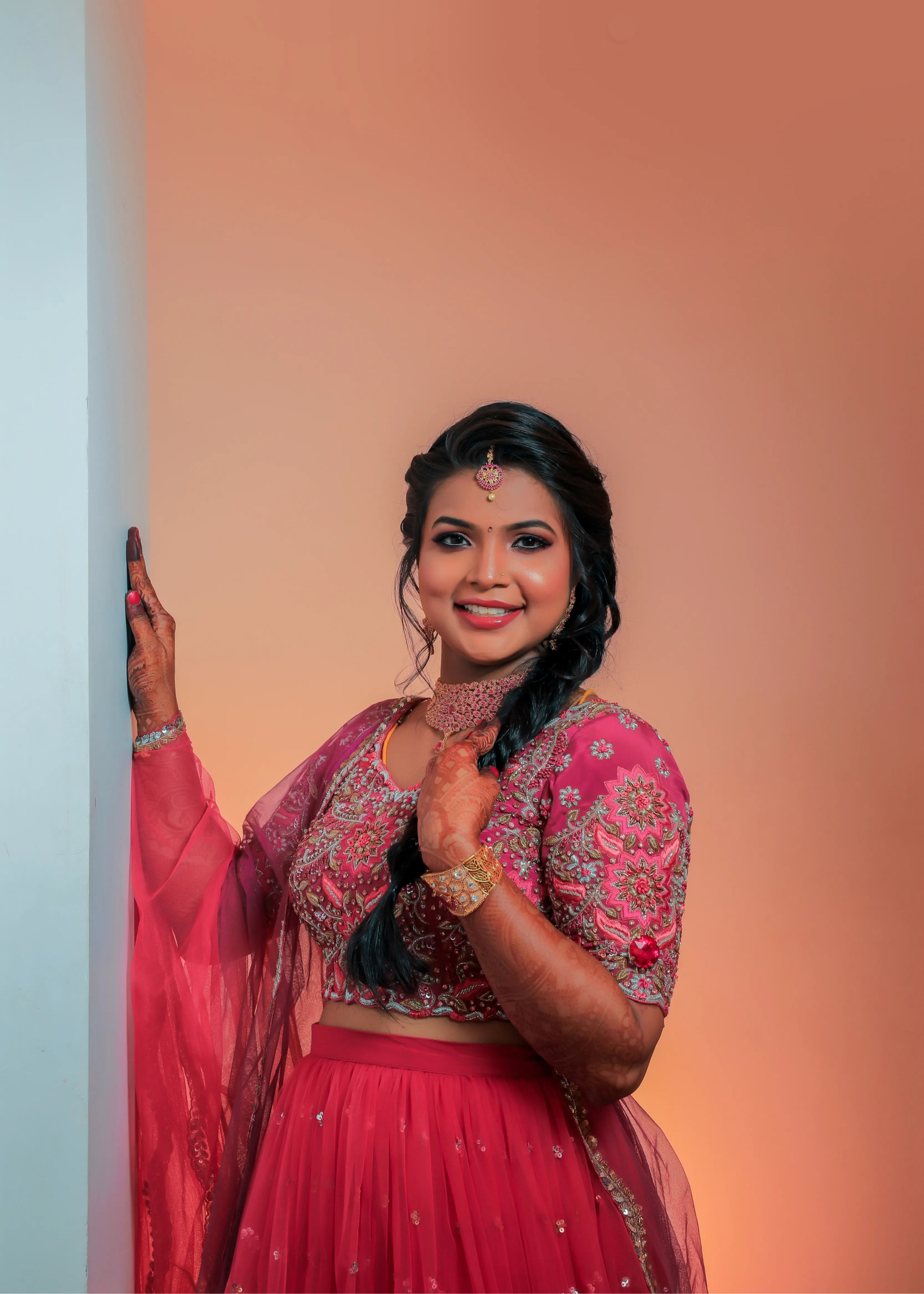 Bride from Chennai in a side pose in a handcrafted pink tulle with heavily embellished blouse with zardozi, rhinestones, cut dana, sequin and resham knot work.