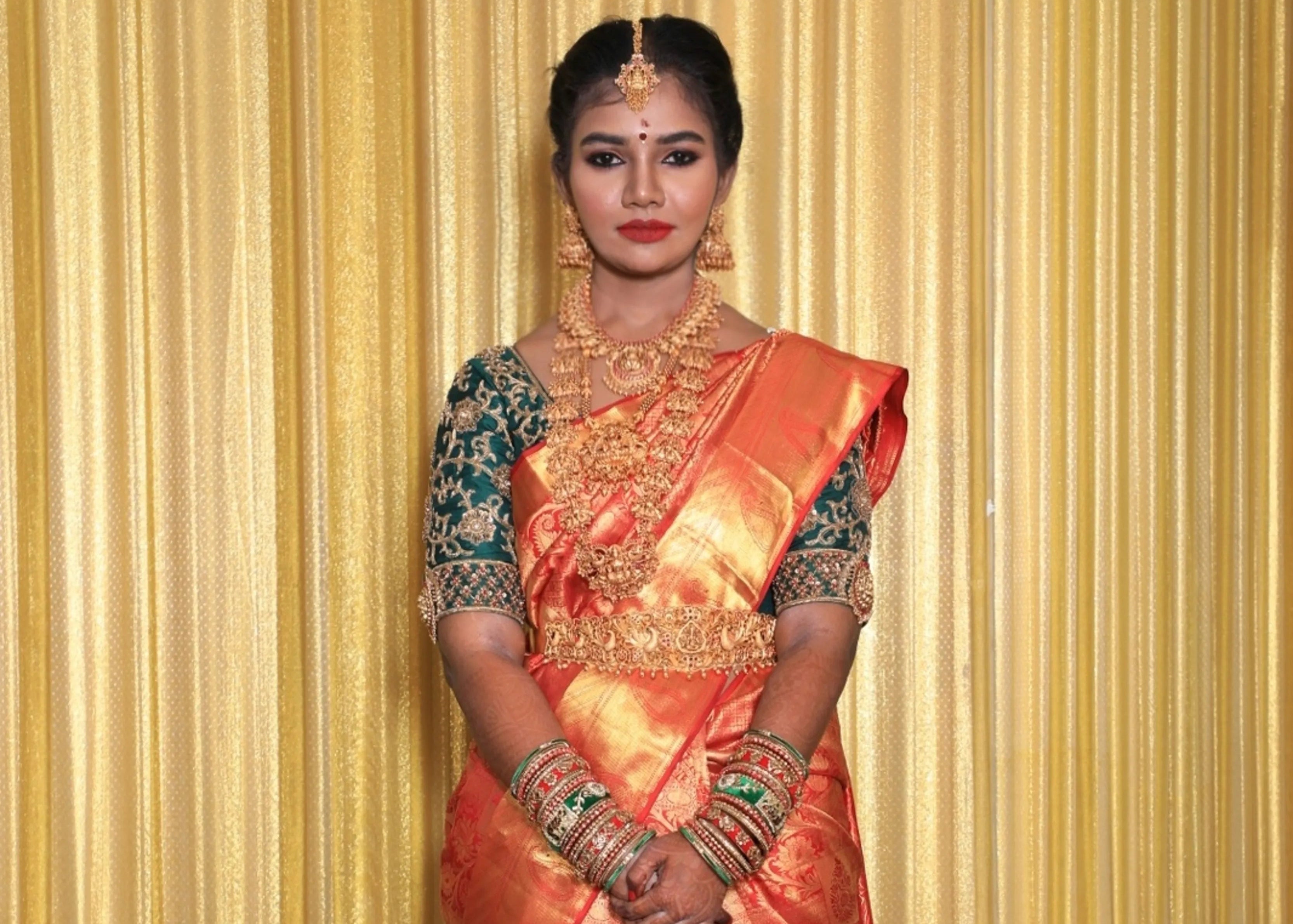 Bride from Chennai in bottle green silk blouse embellished with zardozi and goddess pendants on sleeves.