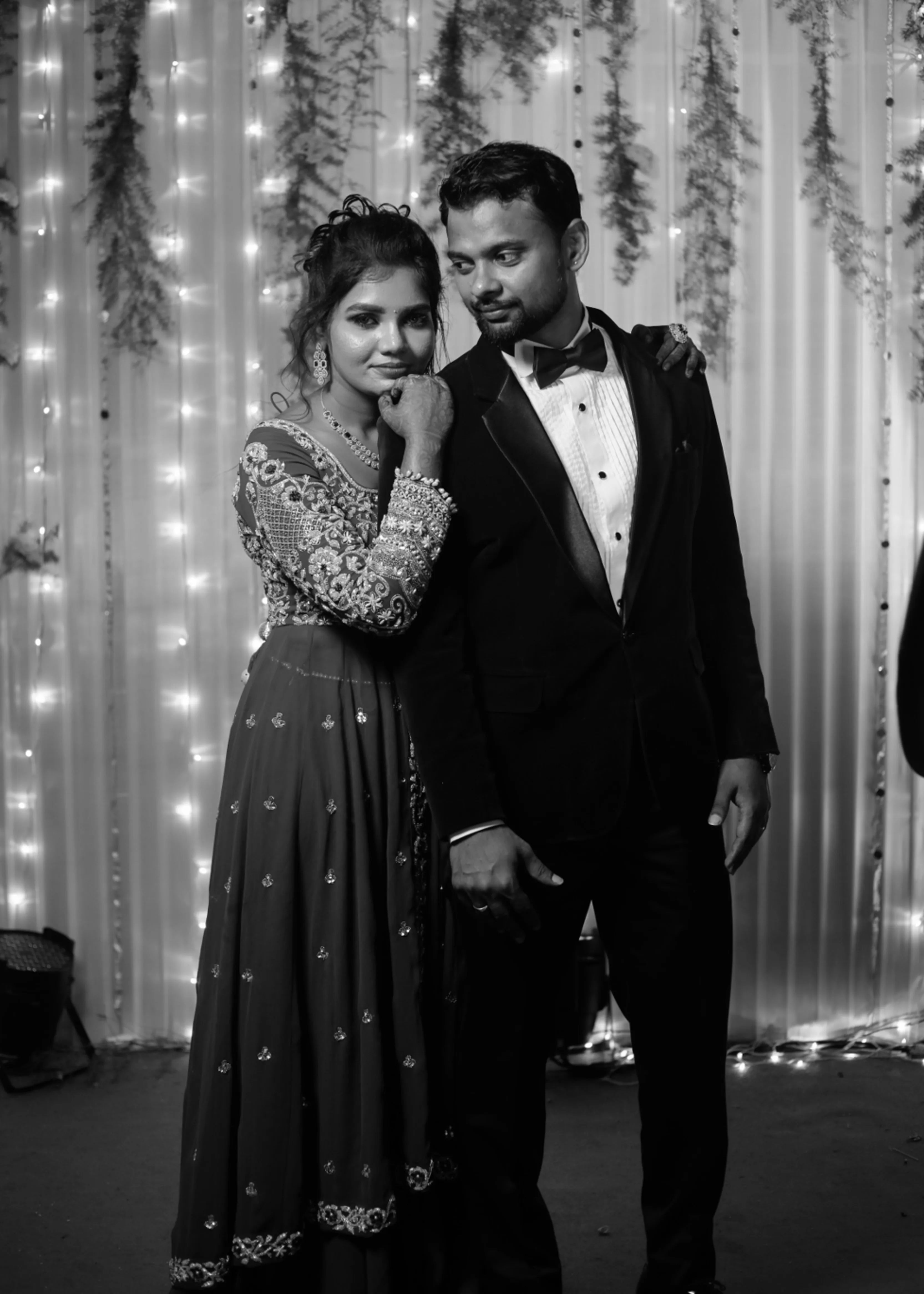 Bride from Chennai leaning on groom for a photo in navy blue masakali lehenga with silver embellishments designed by Archana Karthick