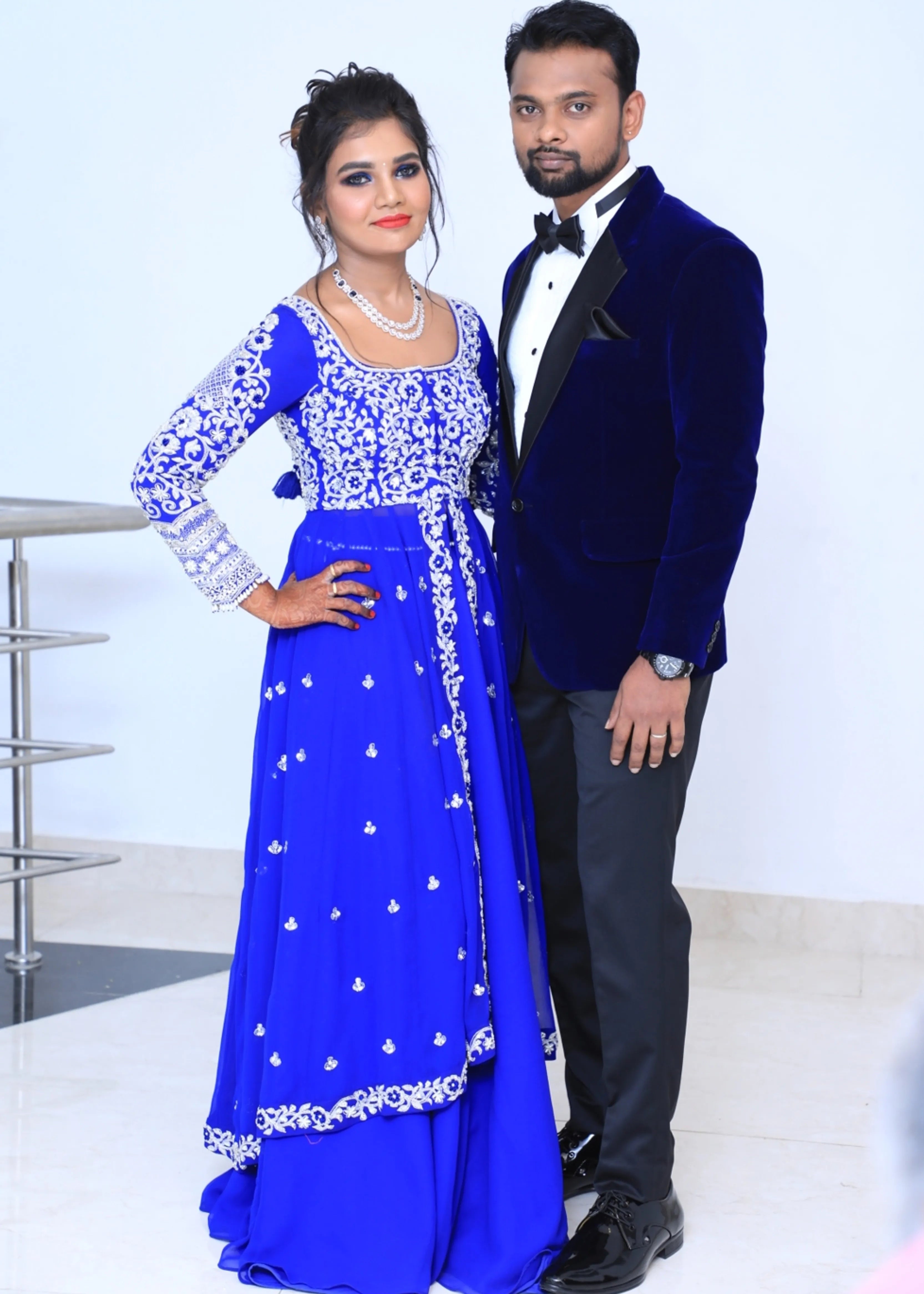 Bride from Chennai poasing with groom in navy blue masakali lehenga with silver embellishments designed by Archana Karthick