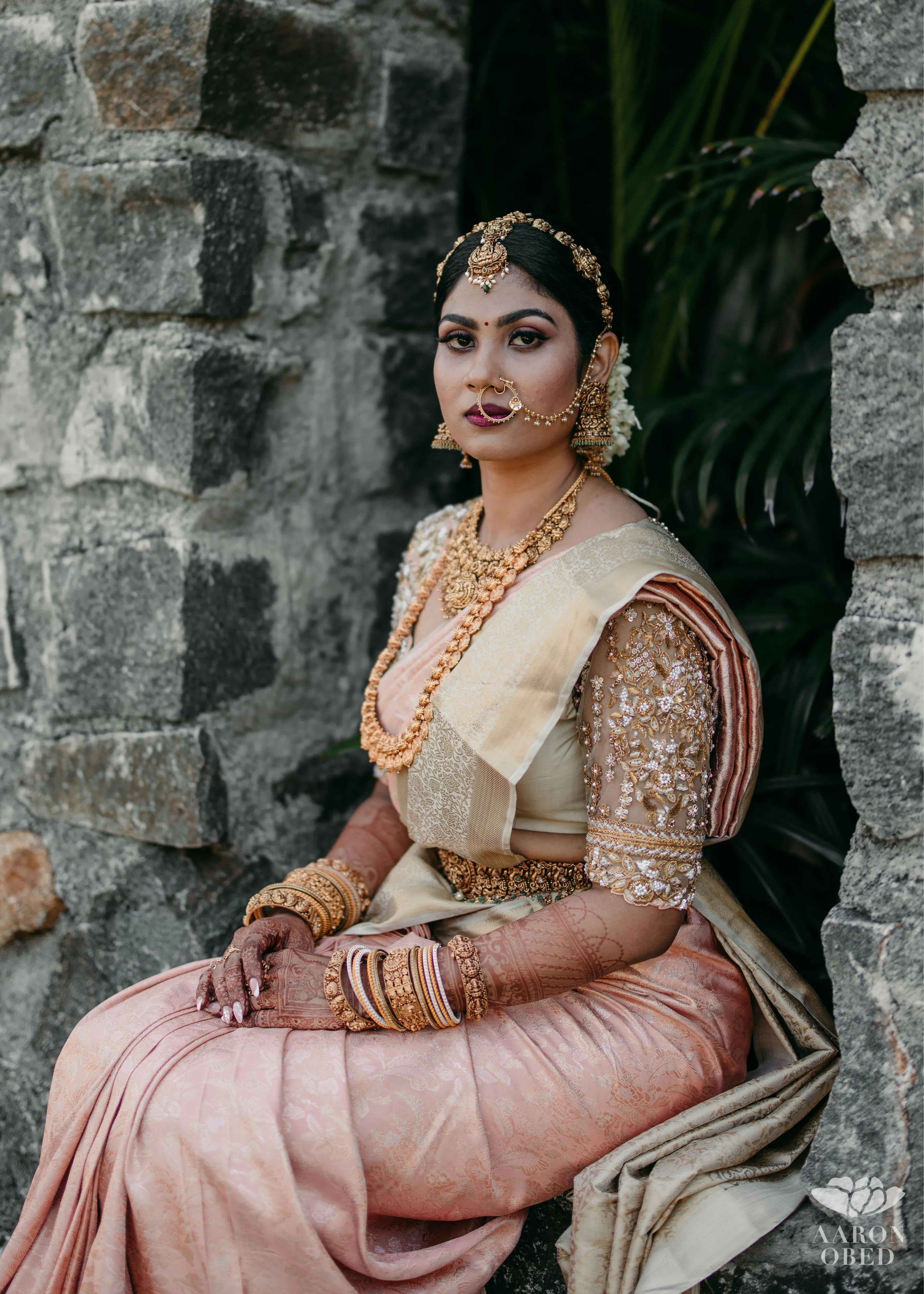 Bride from Chennai seated in a concept blouse in grey tulle and silk, handcrafted intricately with zardozi, crystal beads, stones, pearls and beads. Designed by Archana Karthick.