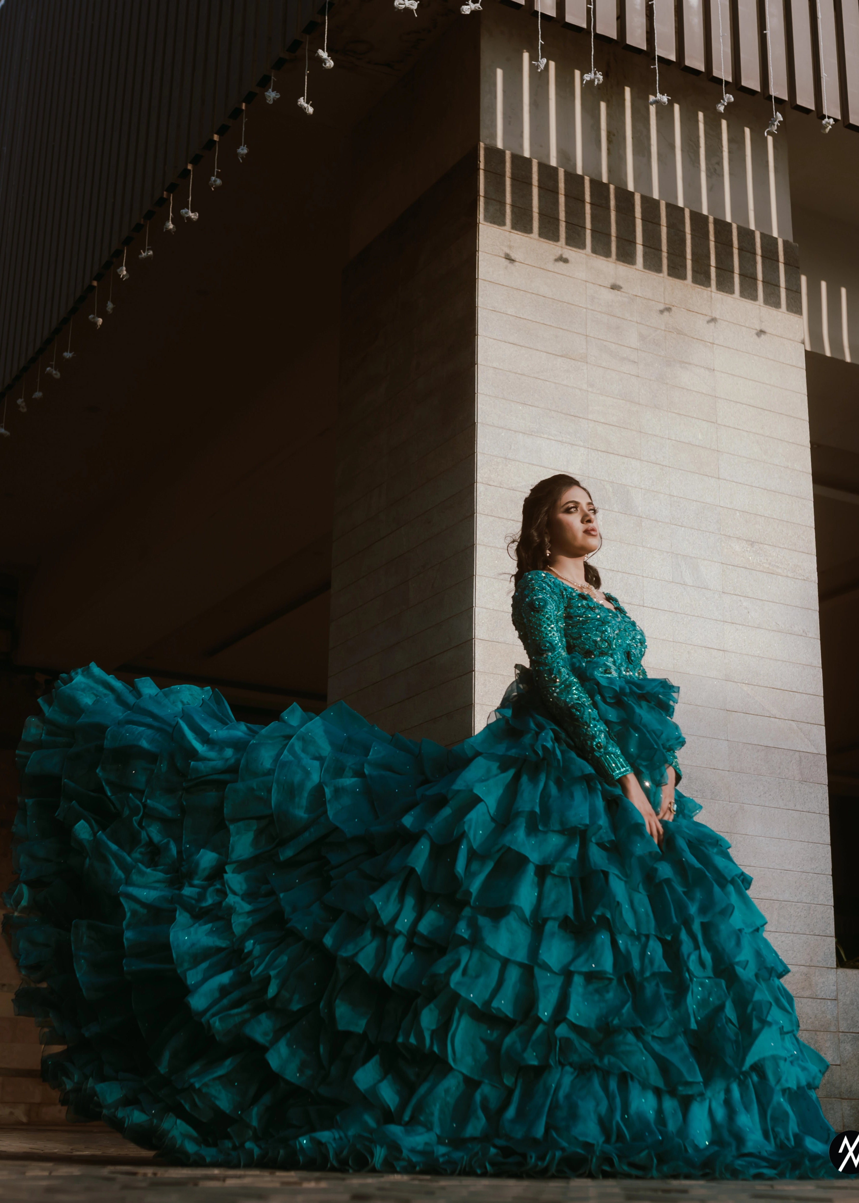 Bride from Coimbatore posing in a pleasted and layered gown handcrafted with stones, rhinestones, cutdanas, sequins and appliques designed by Archana Karthick.