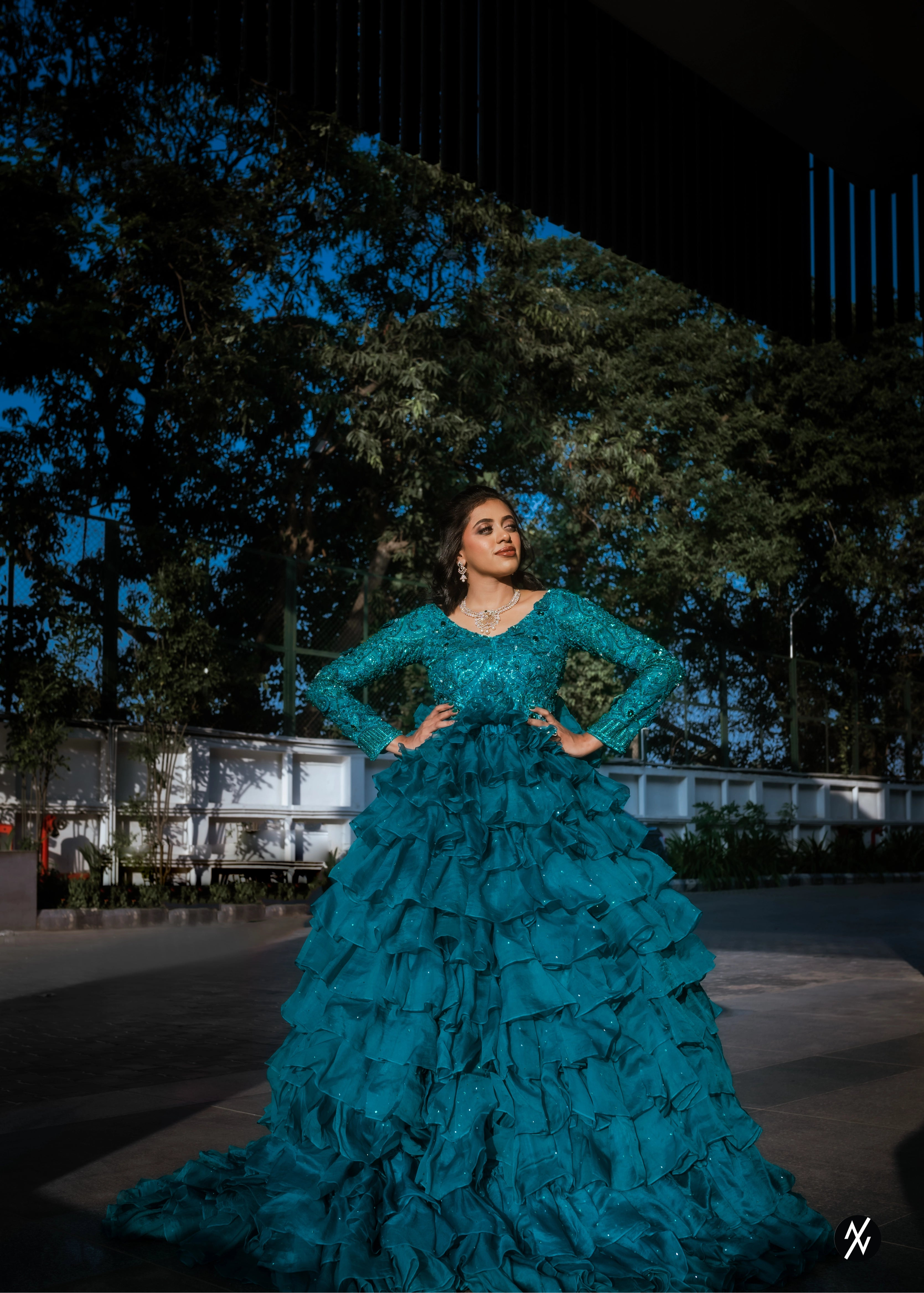 Bride from Coimbatore smiling in a pleasted and layered gown handcrafted with stones, rhinestones, cutdanas, sequins and appliques designed by Archana Karthick.