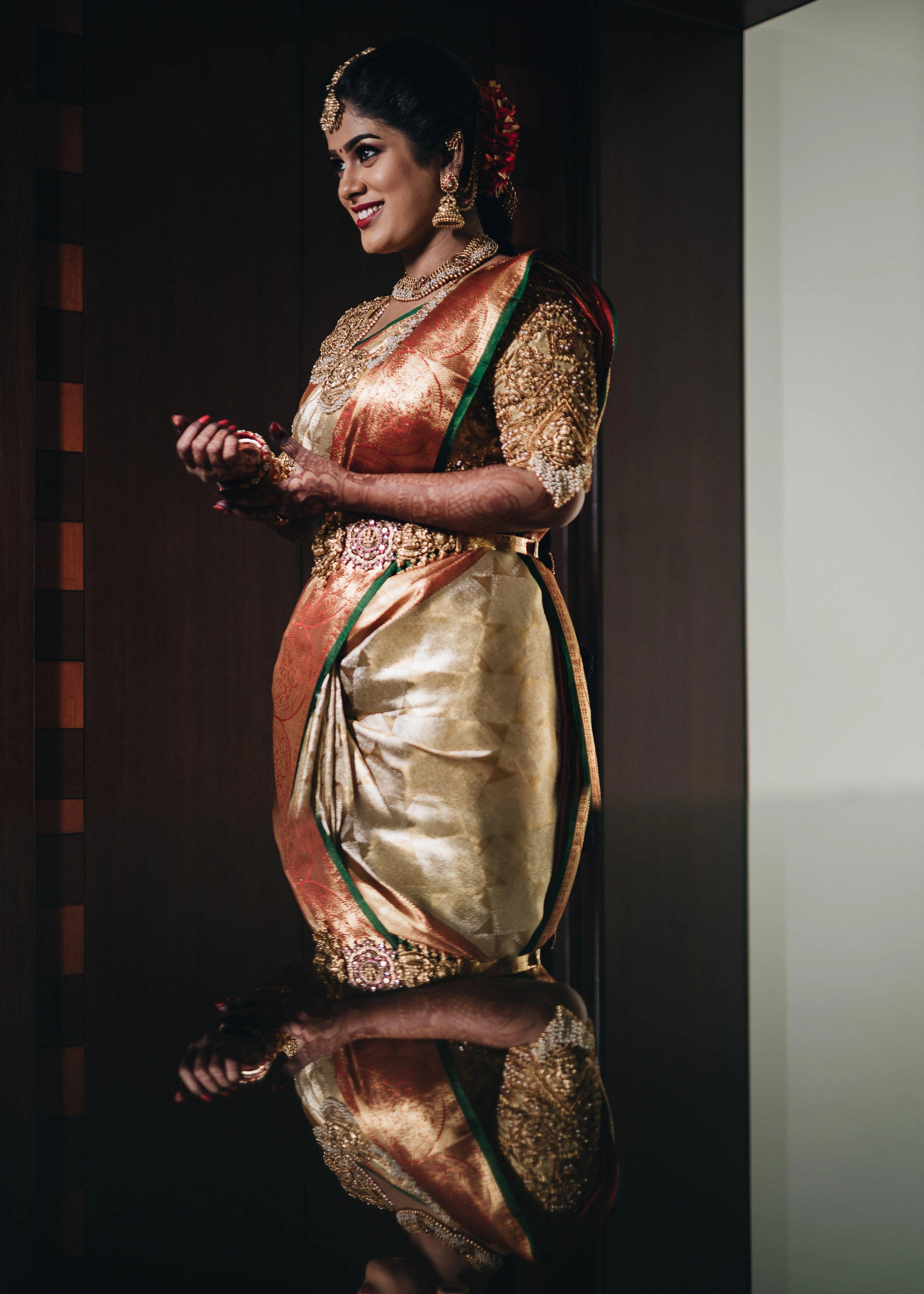 Bride from Erode in a handcrafted gold silk blouse designed by Archana Karthick posing with a smile