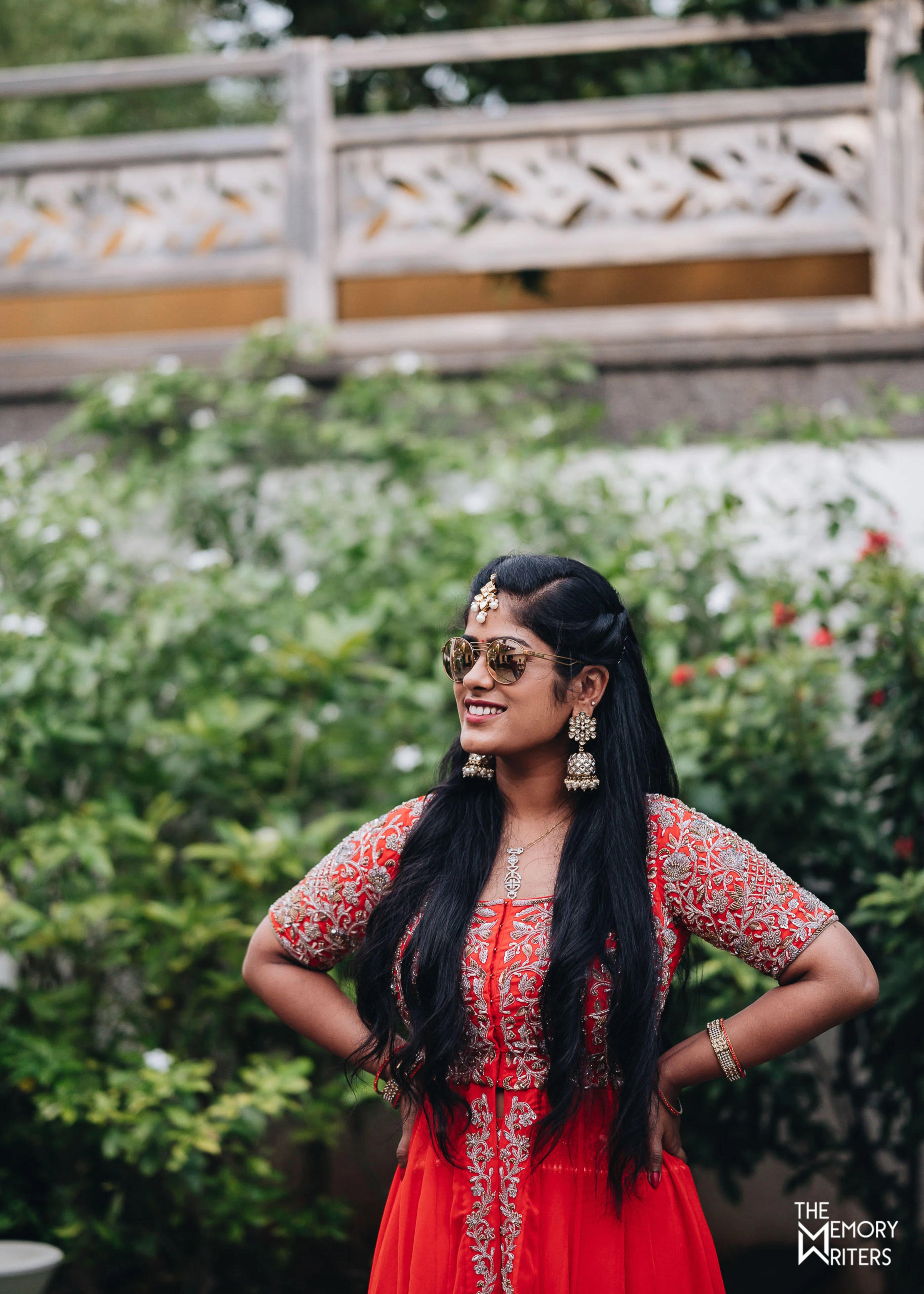 Bride from Erode smiling in a handcrafted orange masakali lehenga with cut dana, sequins and beads in tulle.