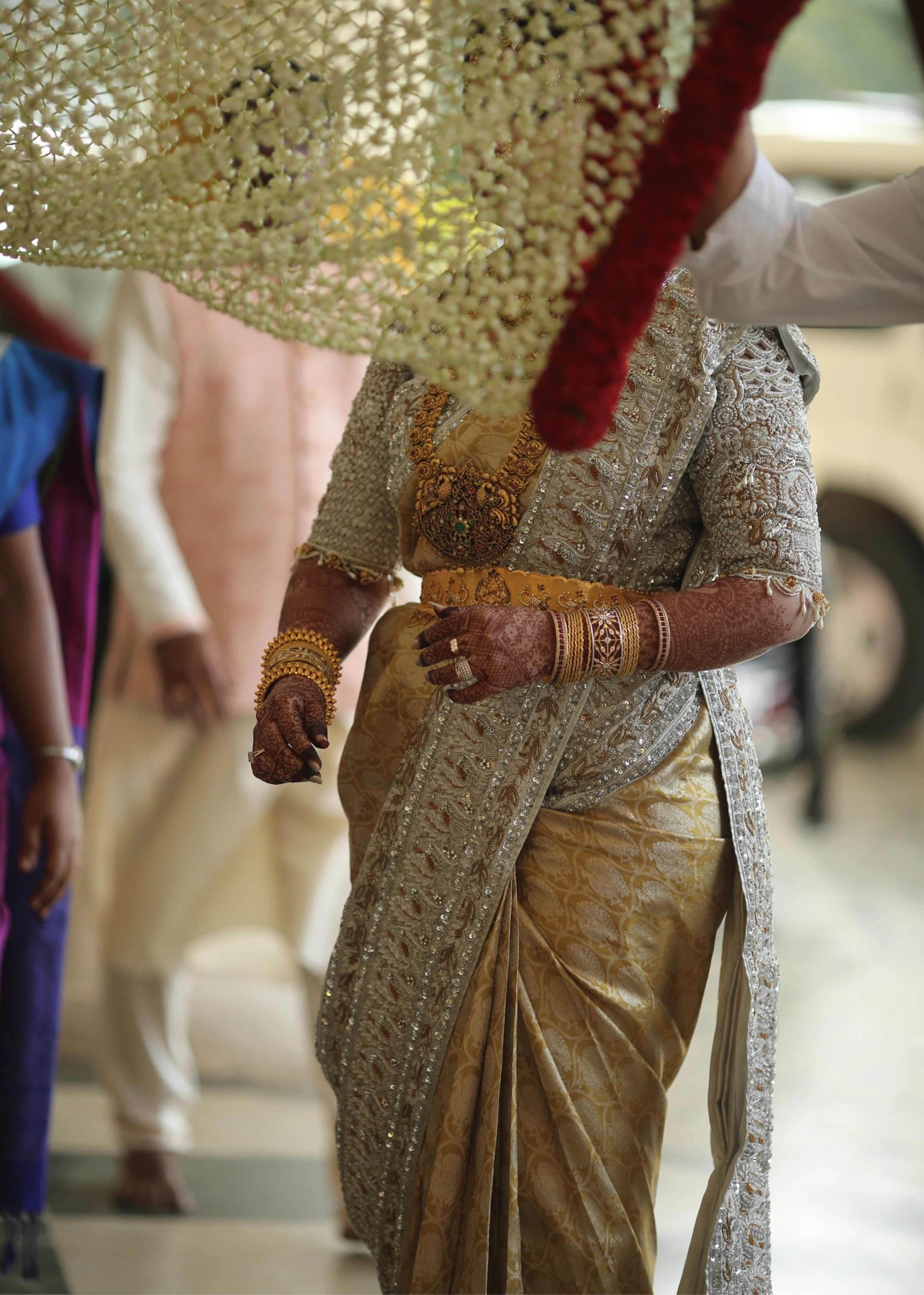 Bride from Kuwait behind in a silver silk blouse and saree border handcrafted with stones, crystals, zardozi, beads, rhinestones, cutdanas and sequins. Designed by Archana Karthick.