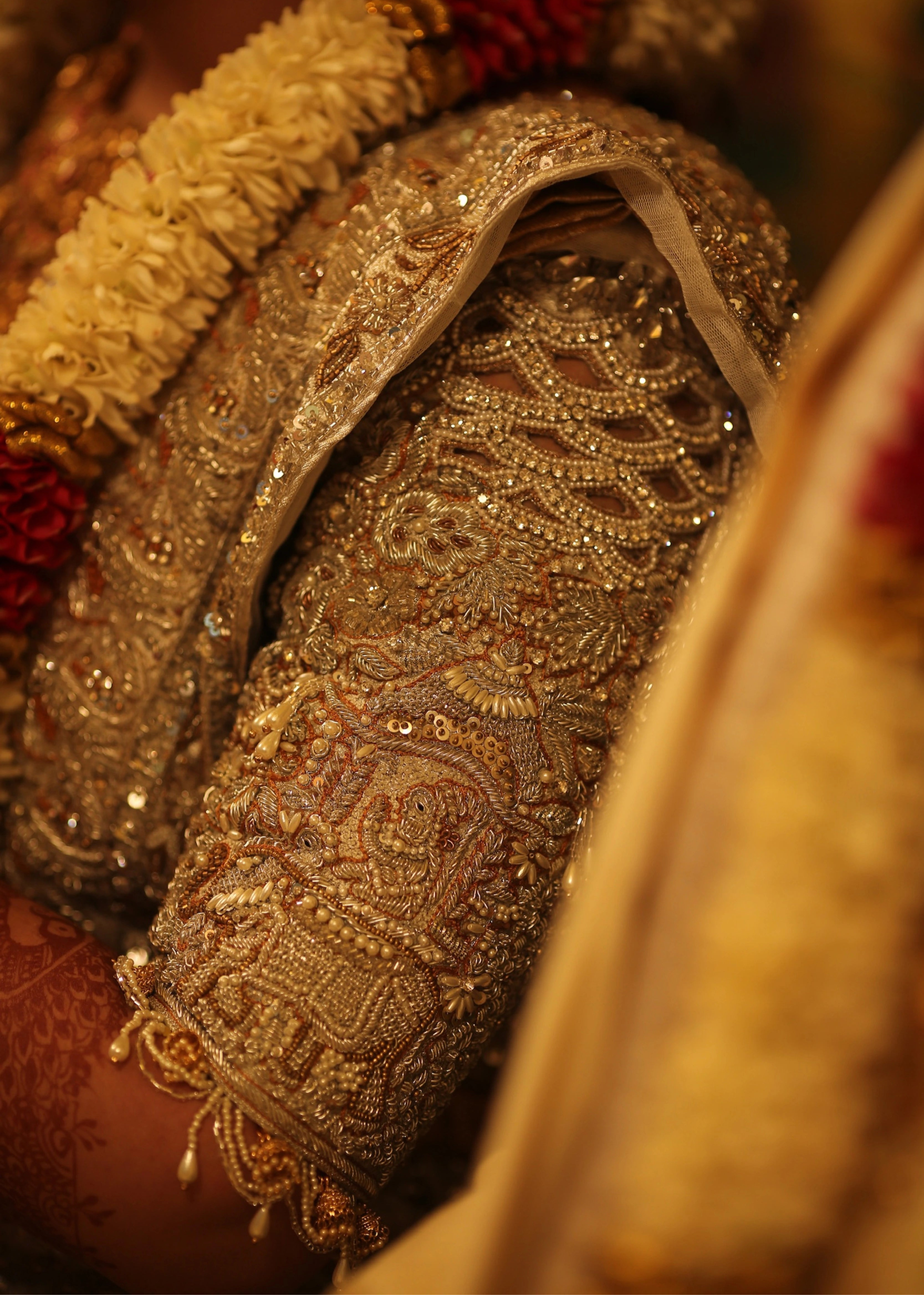 Bride from Kuwait for left sleeve pose in a silver silk blouse and saree border handcrafted with stones, crystals, zardozi, beads, rhinestones, cutdanas and sequins. Designed by Archana Karthick.