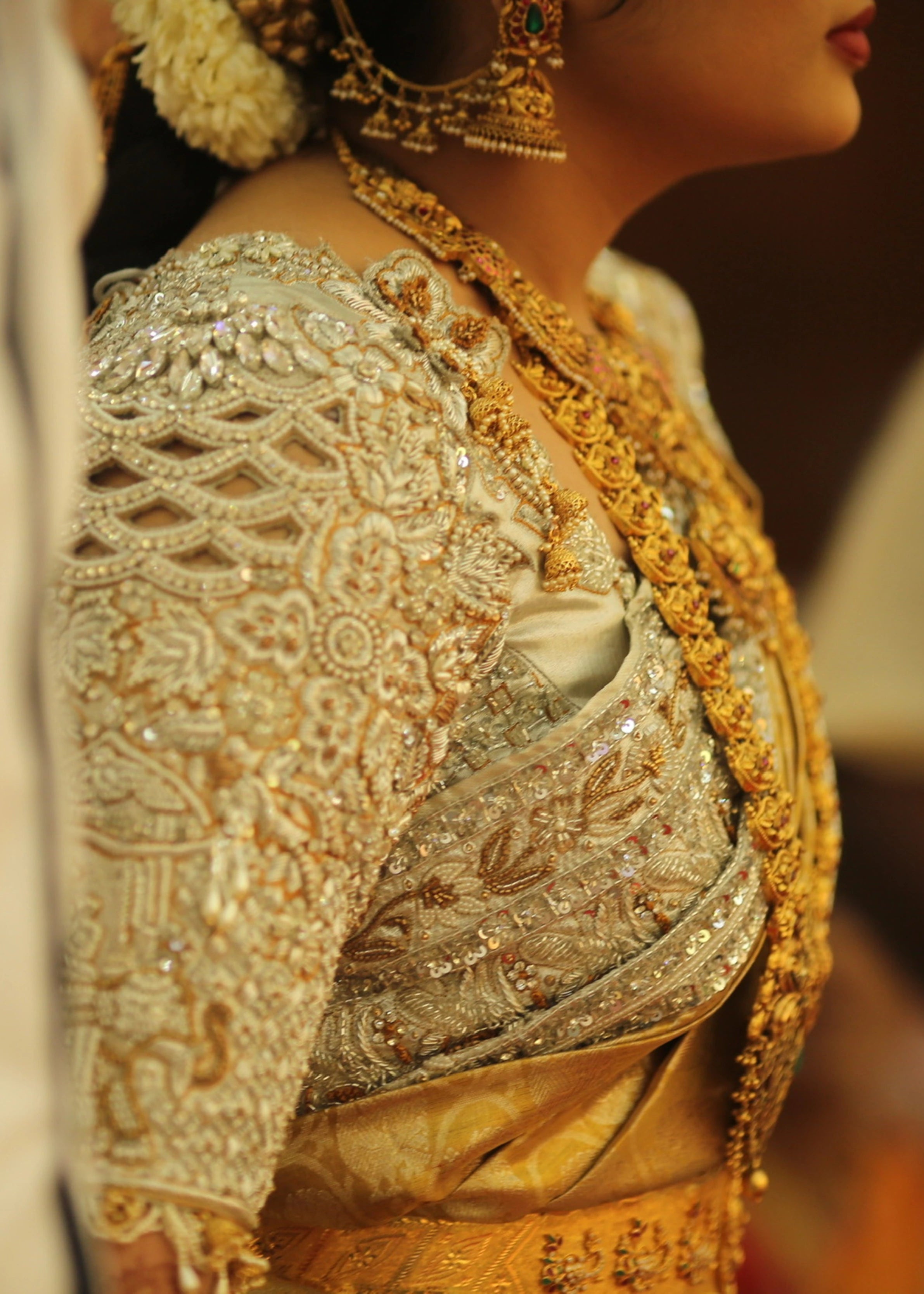 Bride from Kuwait for side profile in a silver silk blouse and saree border handcrafted with stones, crystals, zardozi, beads, rhinestones, cutdanas and sequins. Designed by Archana Karthick.