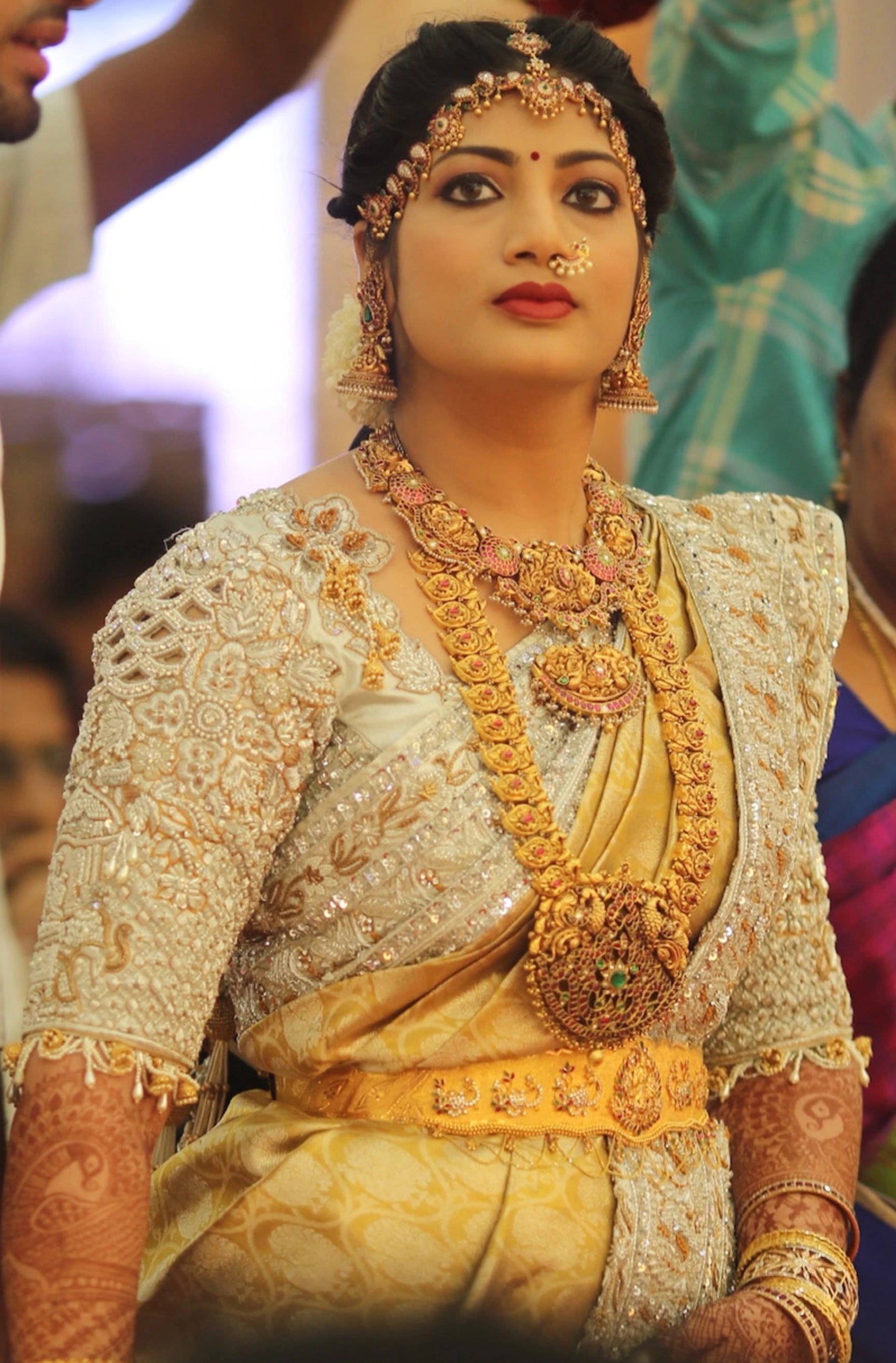Bride from Kuwait looking afar in a silver silk blouse and saree border handcrafted with stones, crystals, zardozi, beads, rhinestones, cutdanas and sequins. Designed by Archana Karthick.
