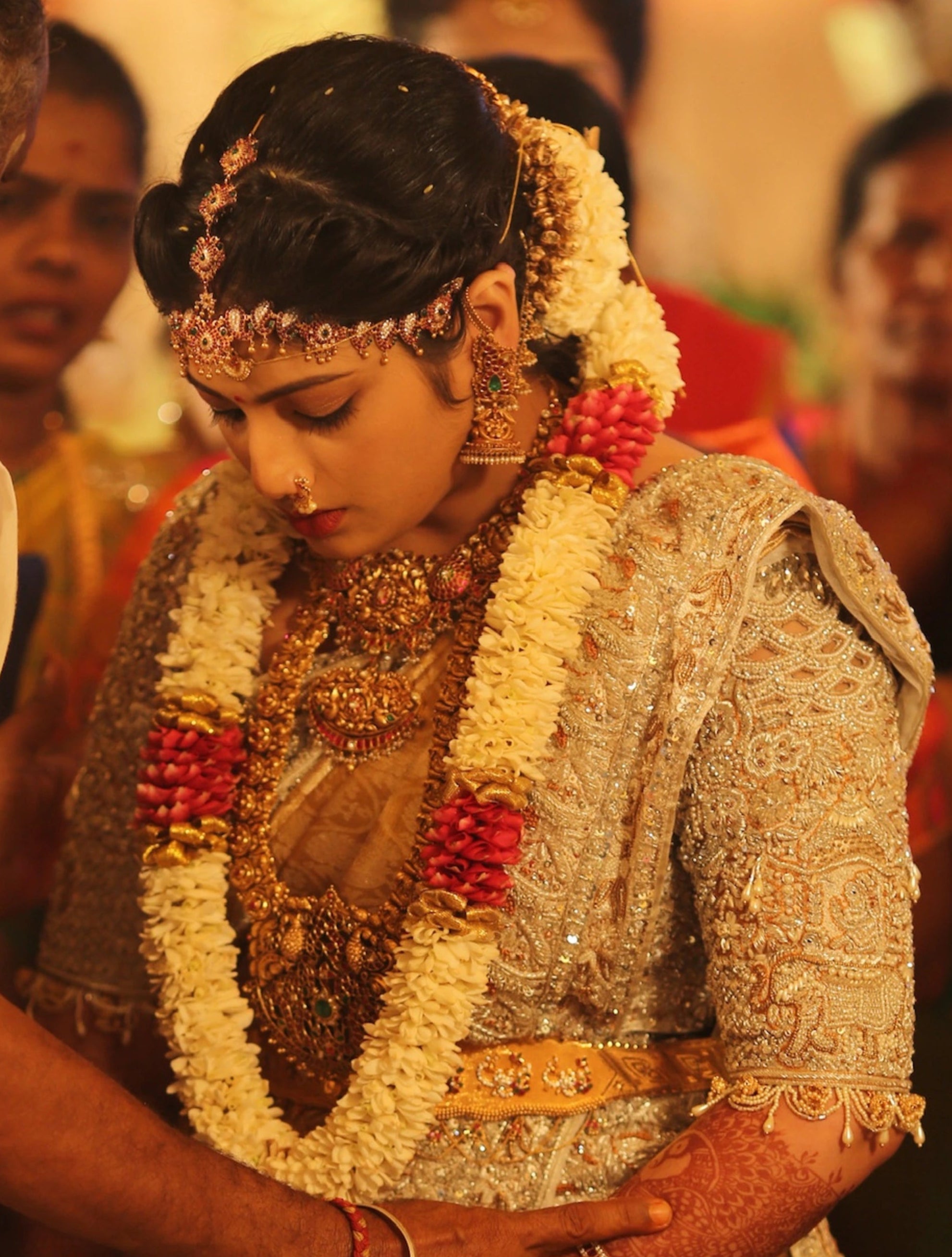 Bride from Kuwait looking down again in a silver silk blouse and saree border handcrafted with stones, crystals, zardozi, beads, rhinestones, cutdanas and sequins. Designed by Archana Karthick.