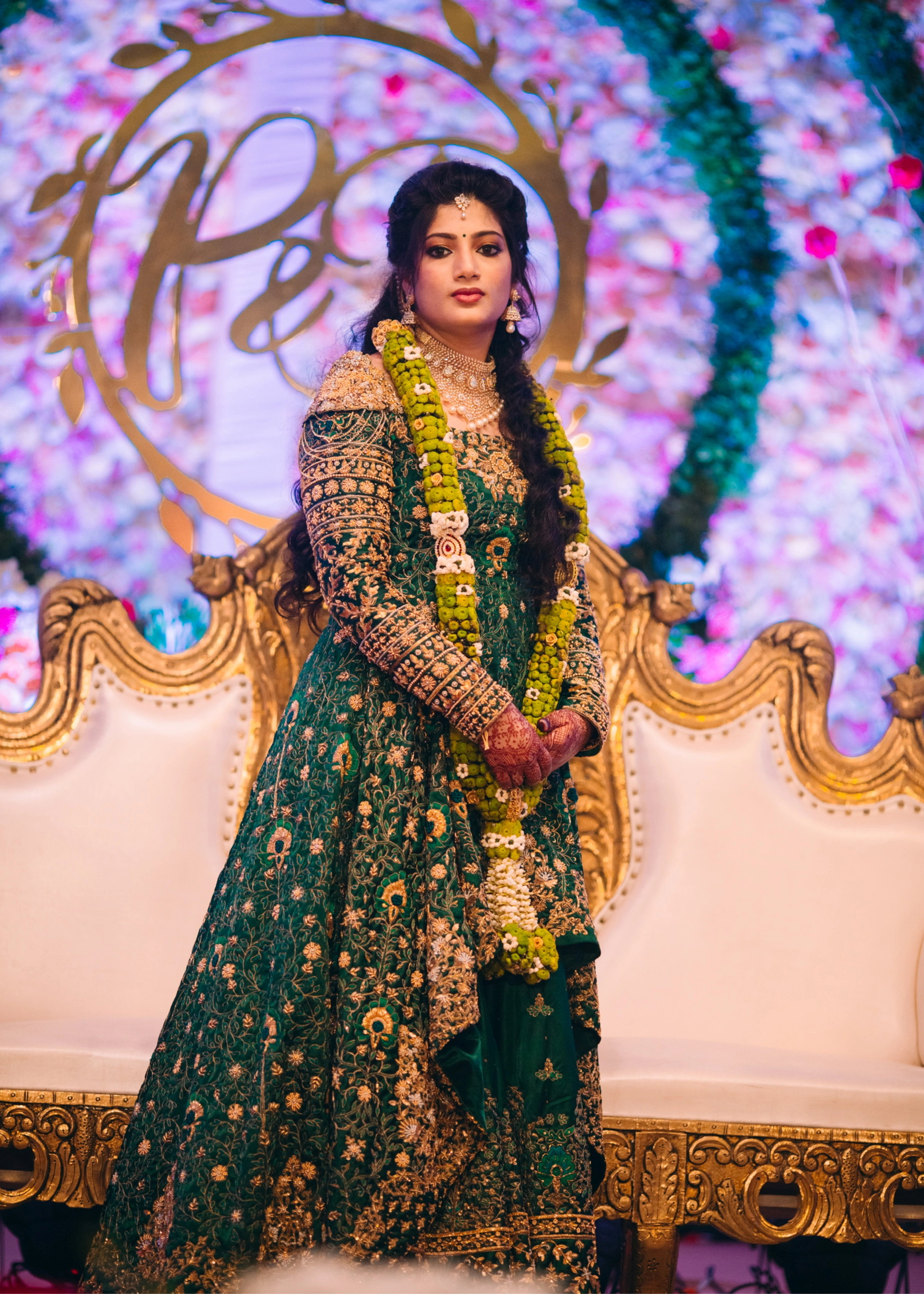 Bride from Kuwait posing in a bottle green satin silk masakali lehenga handcrafted with zardozi, rhinestones, crystals and more. Designed by Archana Karthick.