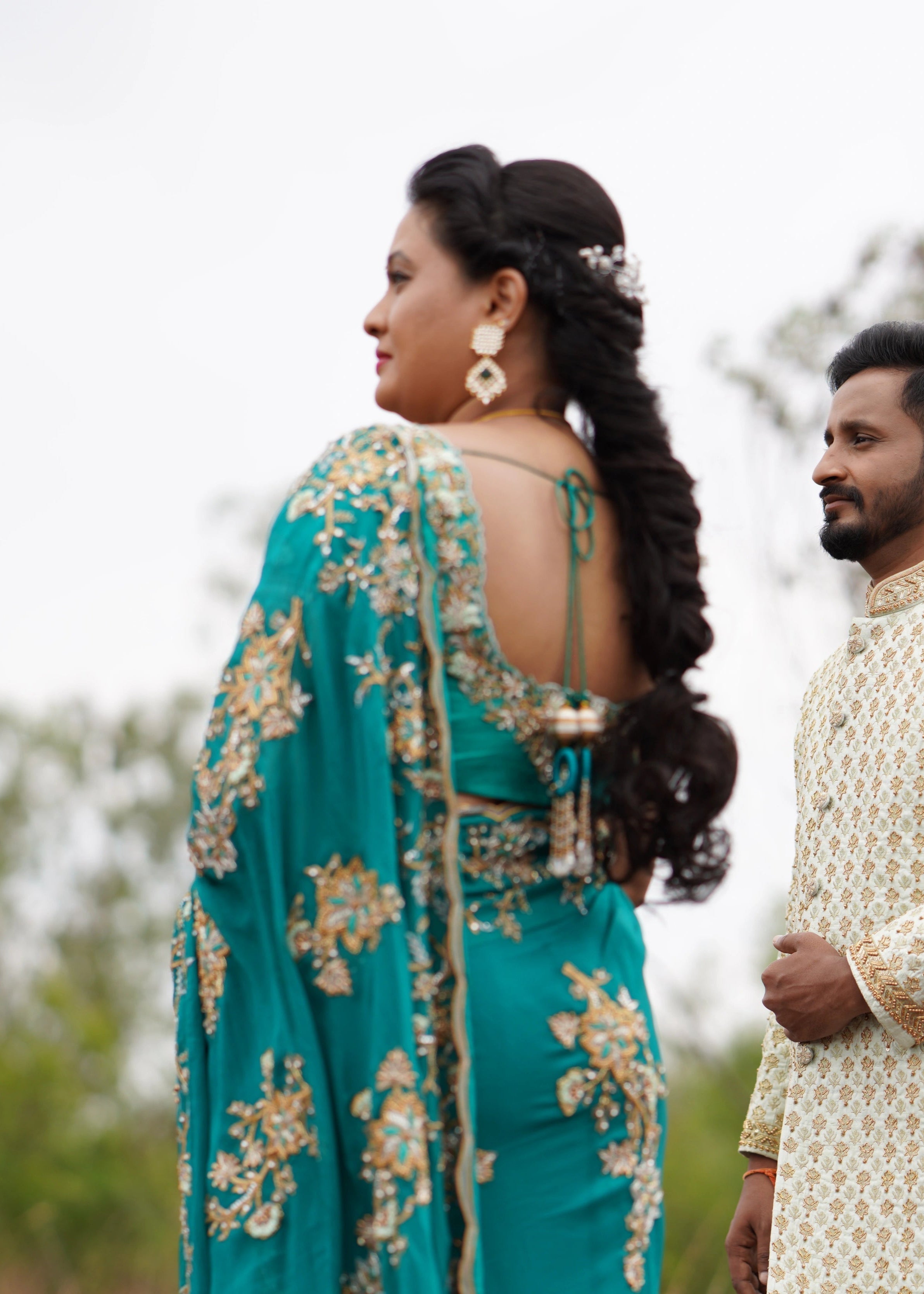 Bride from Seatlle with groom in a teal crepe silk saree handcrafted intricately with stones beads zari cutdanas and resham knot work Designed by Archana Karthick.