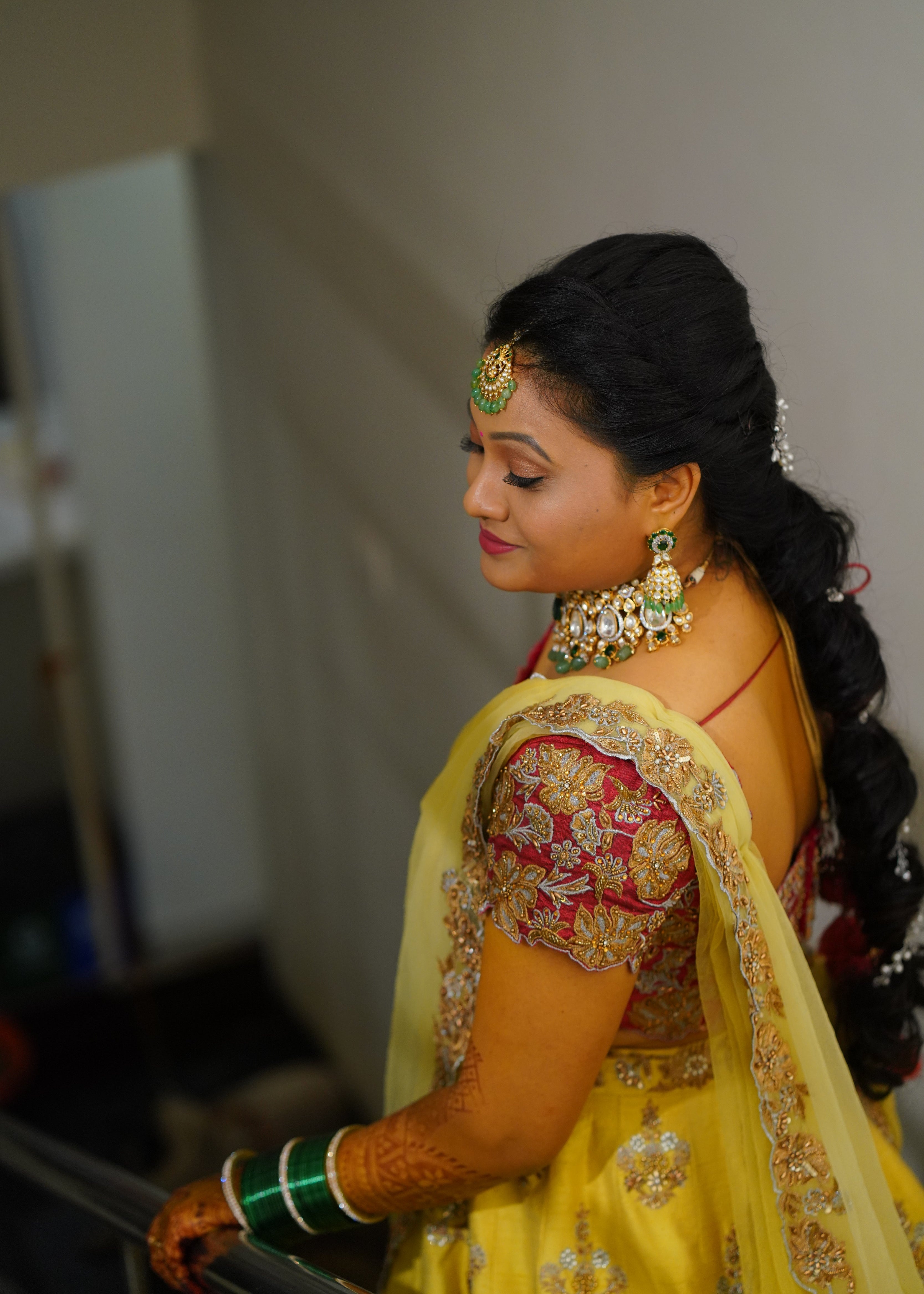 Bride from Seattle posing in a yellow and red raw silk and yellow tulle dupatta handcrafted with zari, beads, cutdanas and sequins. Designed by Archana Karthick.